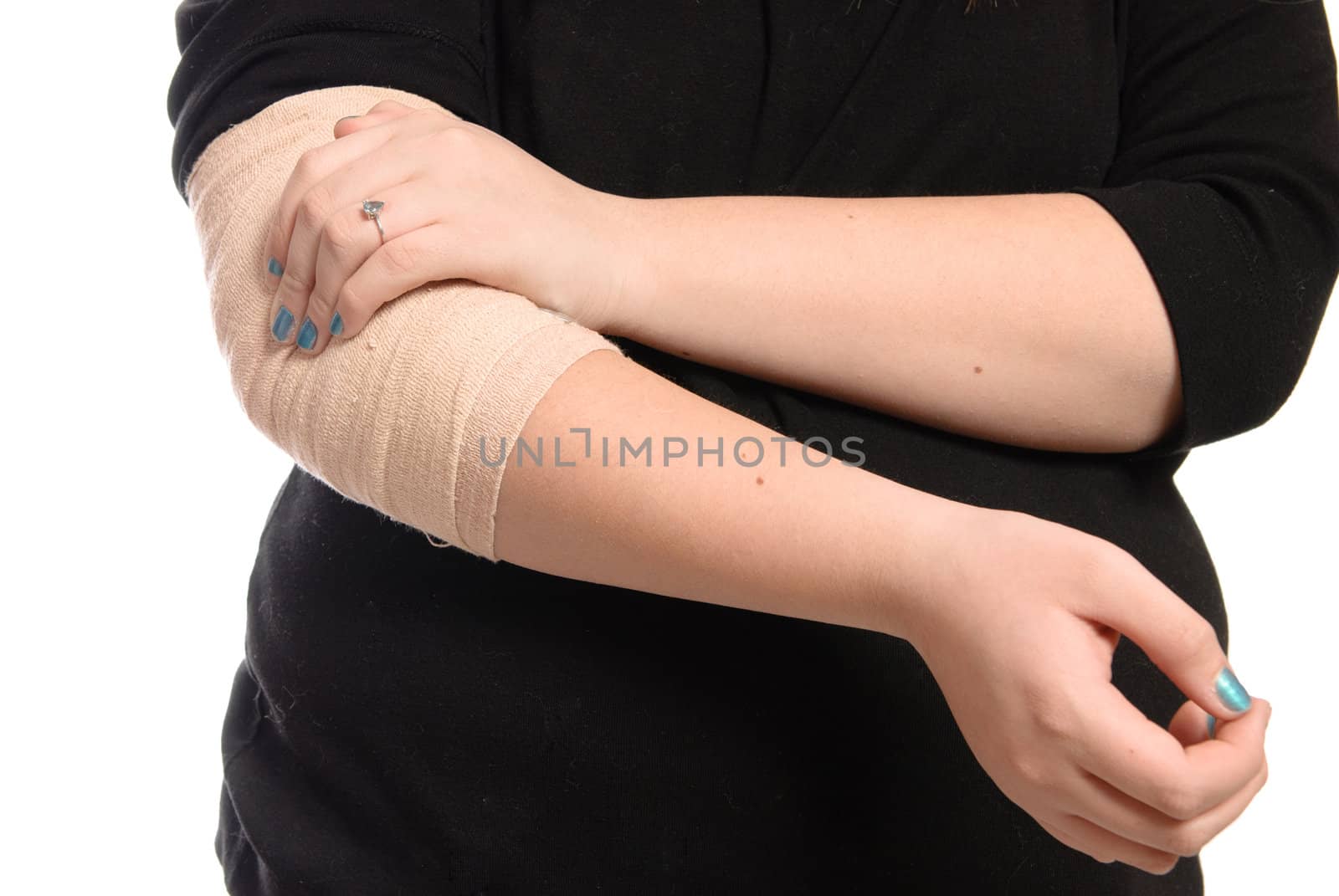 A young girl is holding her elbow which is wrapped in a tensor bandage, isolated against a white background.