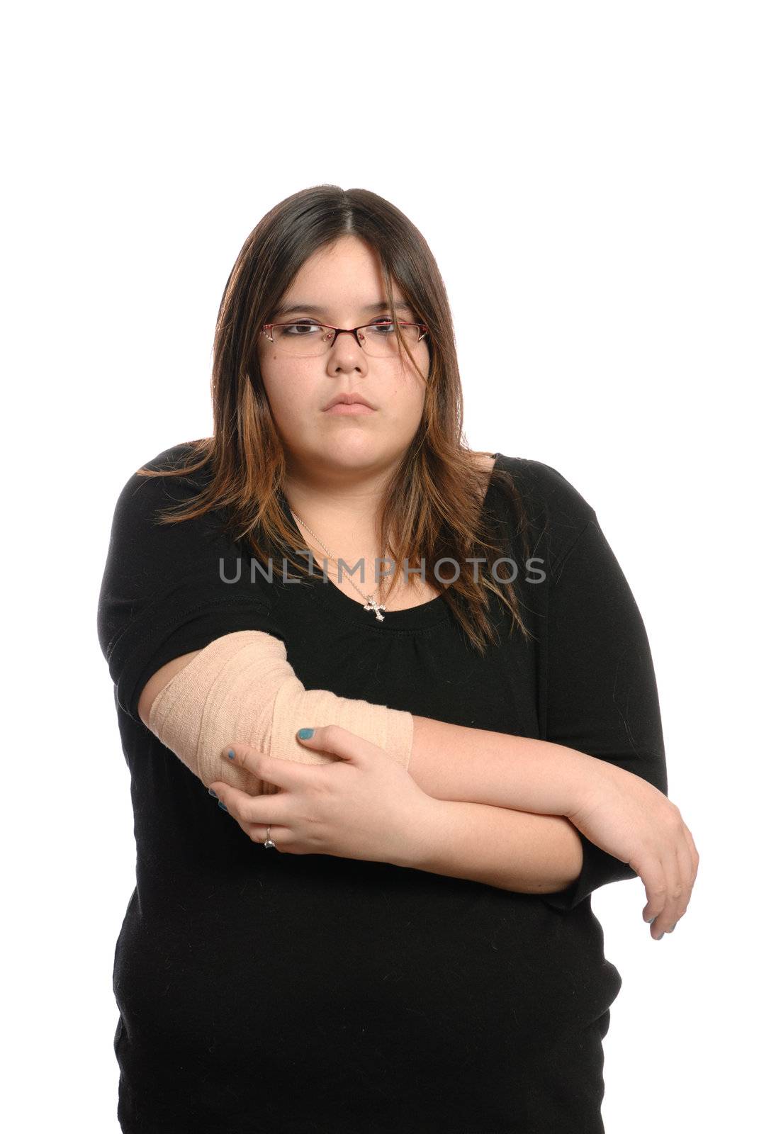 A teenage girl holding her injured elbow with no expression on her face, isolated against a white background.