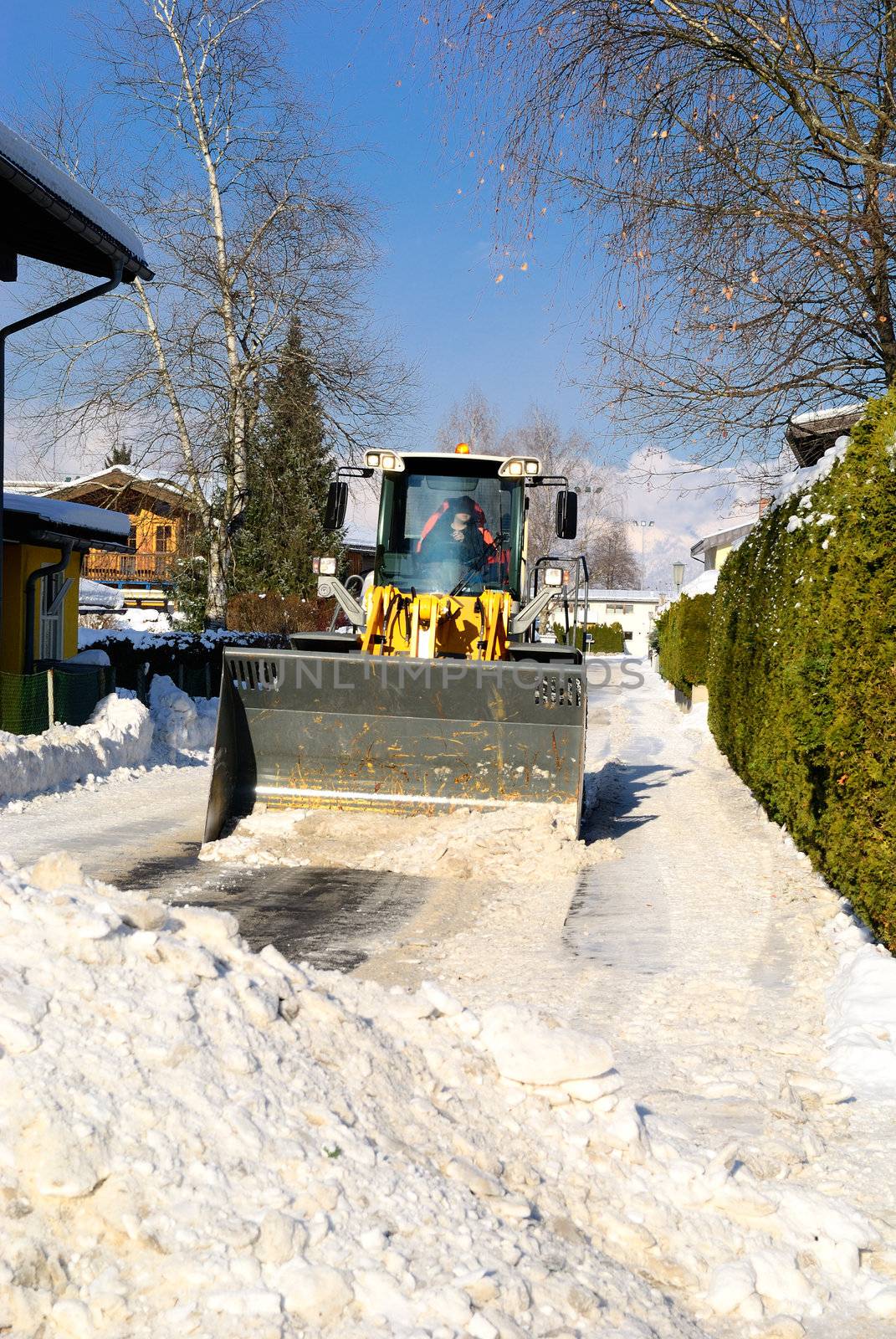 Snowplow cleaning streets in austria after heavy snow storm.