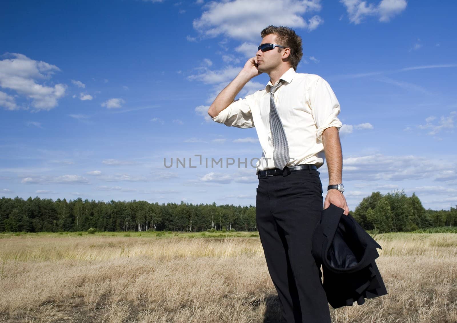 A businessman dressed in a smart suit standing on grass