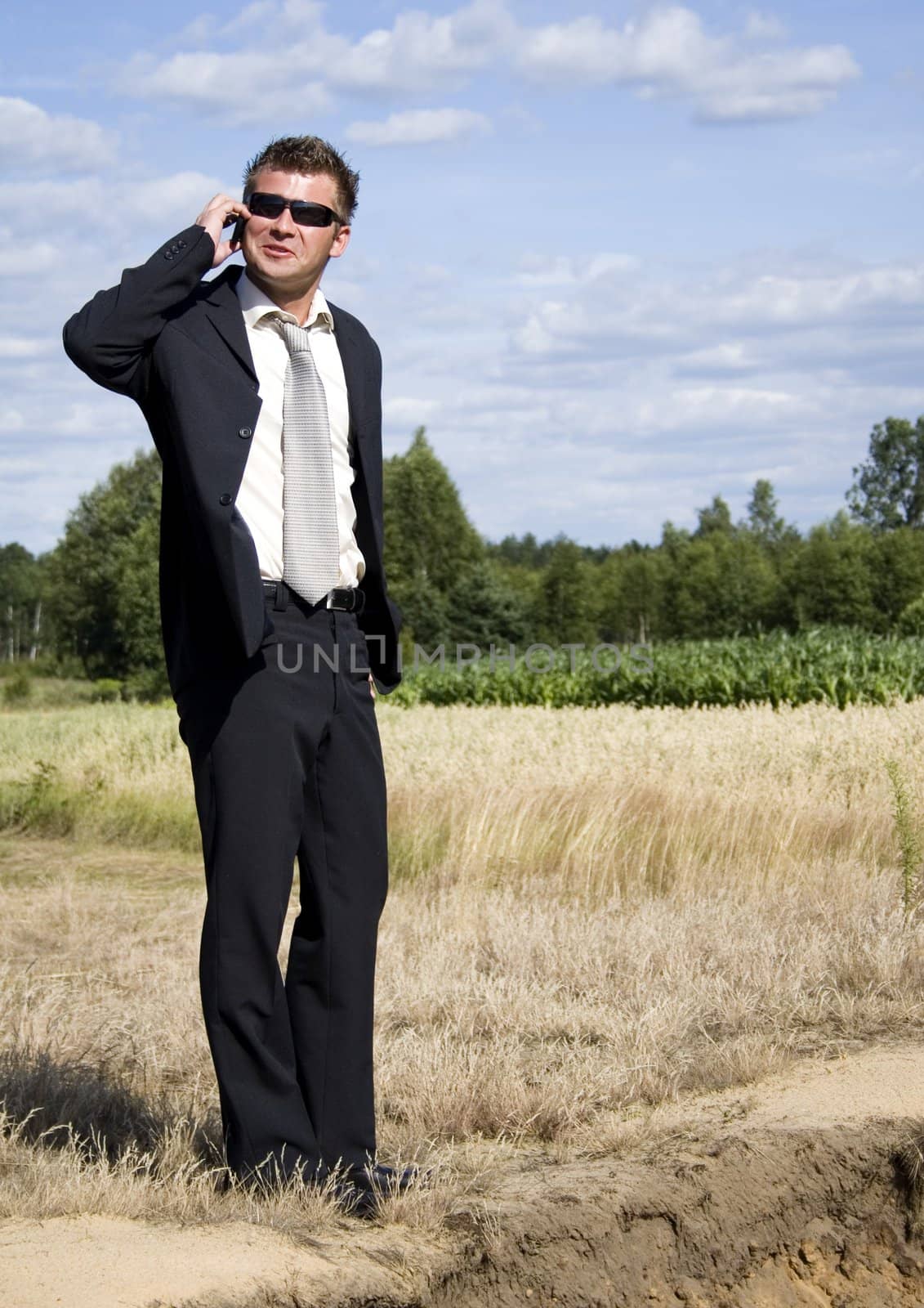 A businessman dressed in a smart suit standing on grass