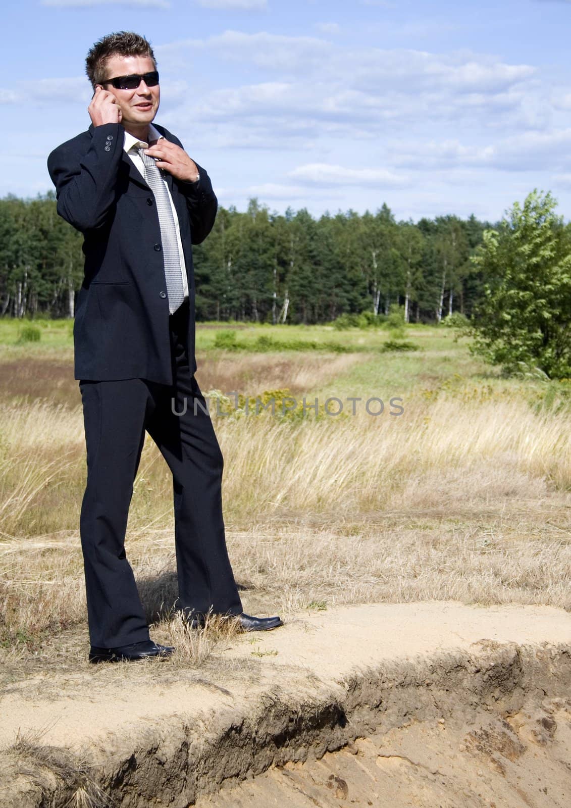 A businessman dressed in a smart suit standing on grass