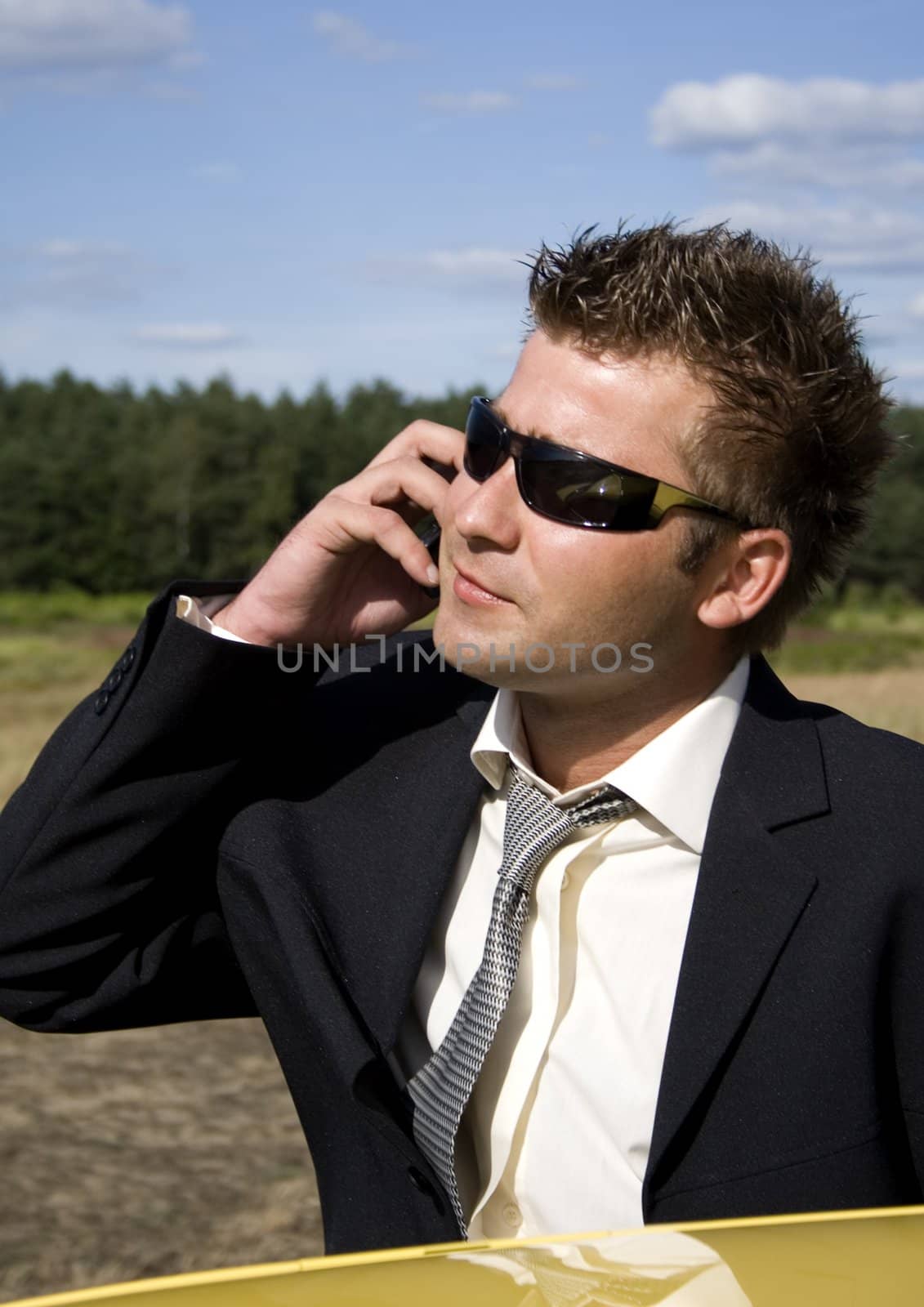 A businessman dressed in a smart suit standing on grass