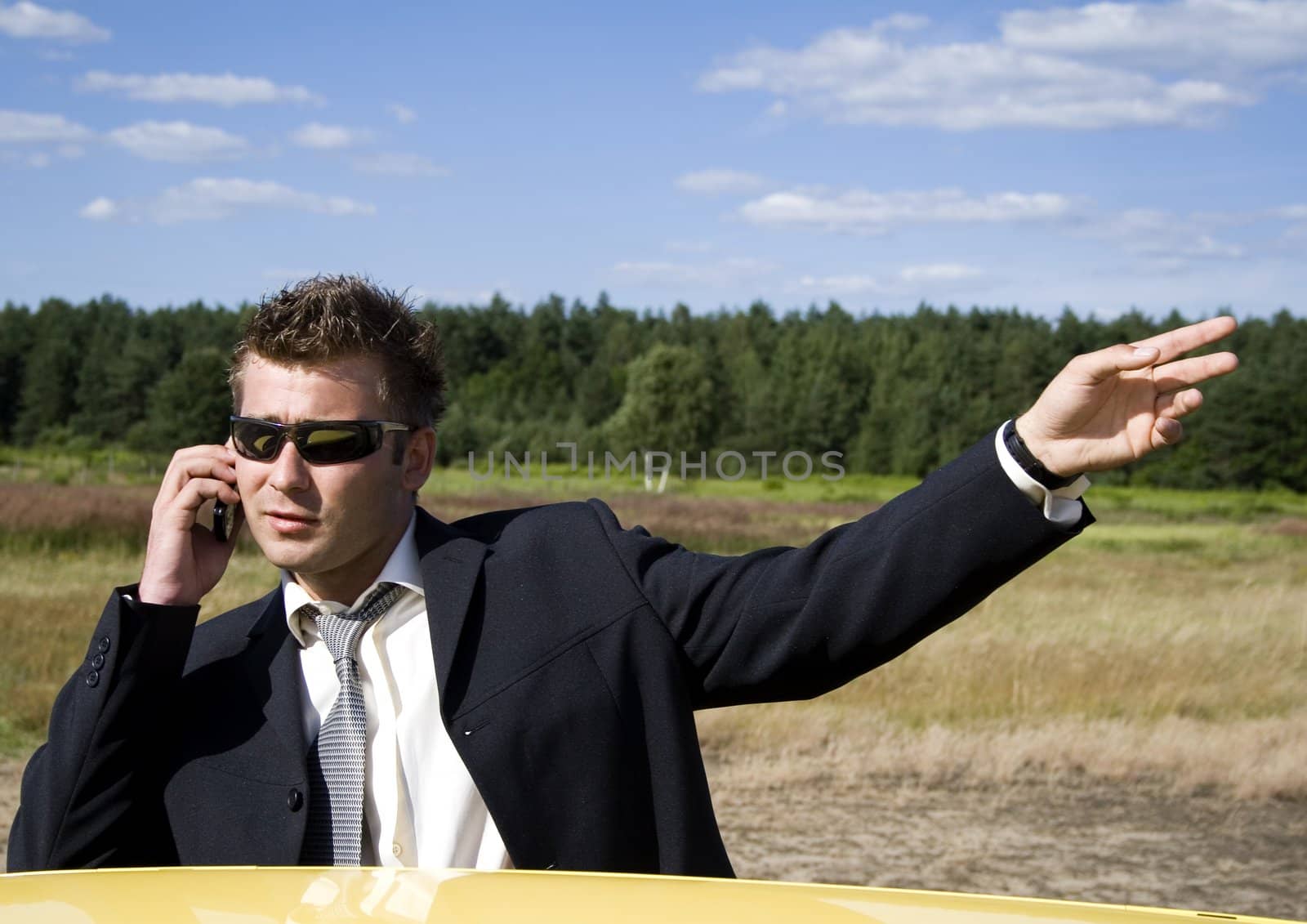 A businessman dressed in a smart suit standing on grass