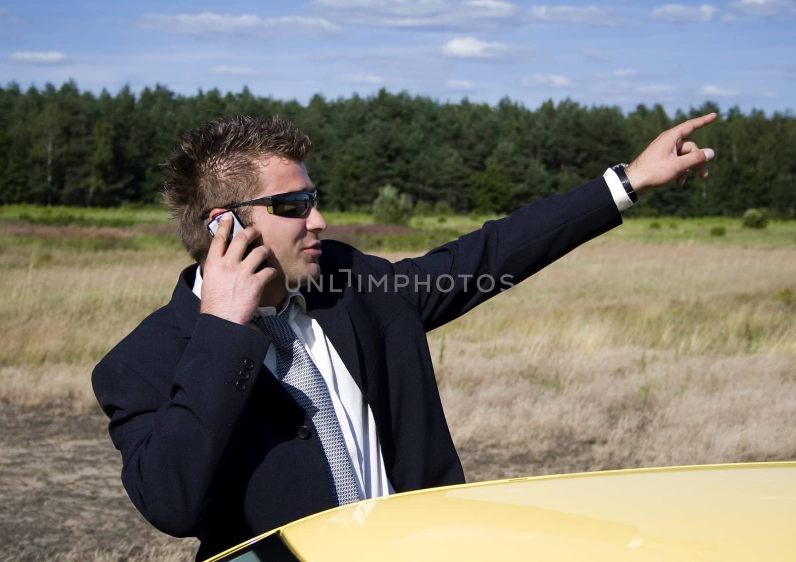 A businessman dressed in a smart suit standing on grass