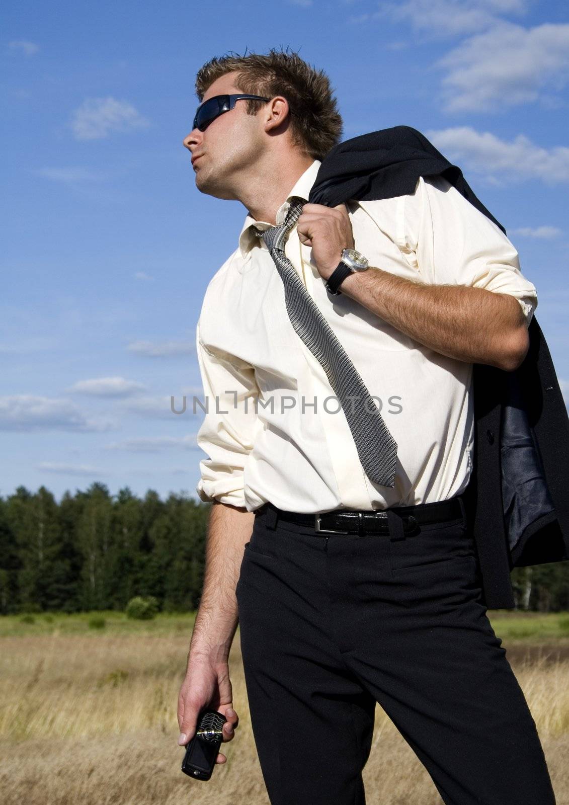 A businessman dressed in a smart suit standing on grass