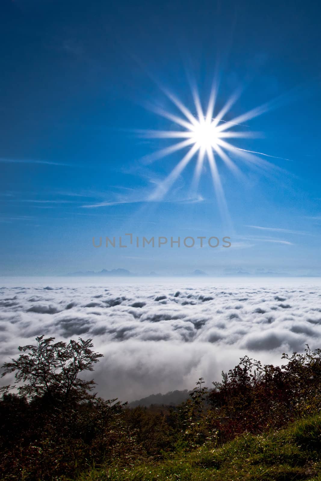 Early morning sun above thick clouds and fog covering Lake Geneva