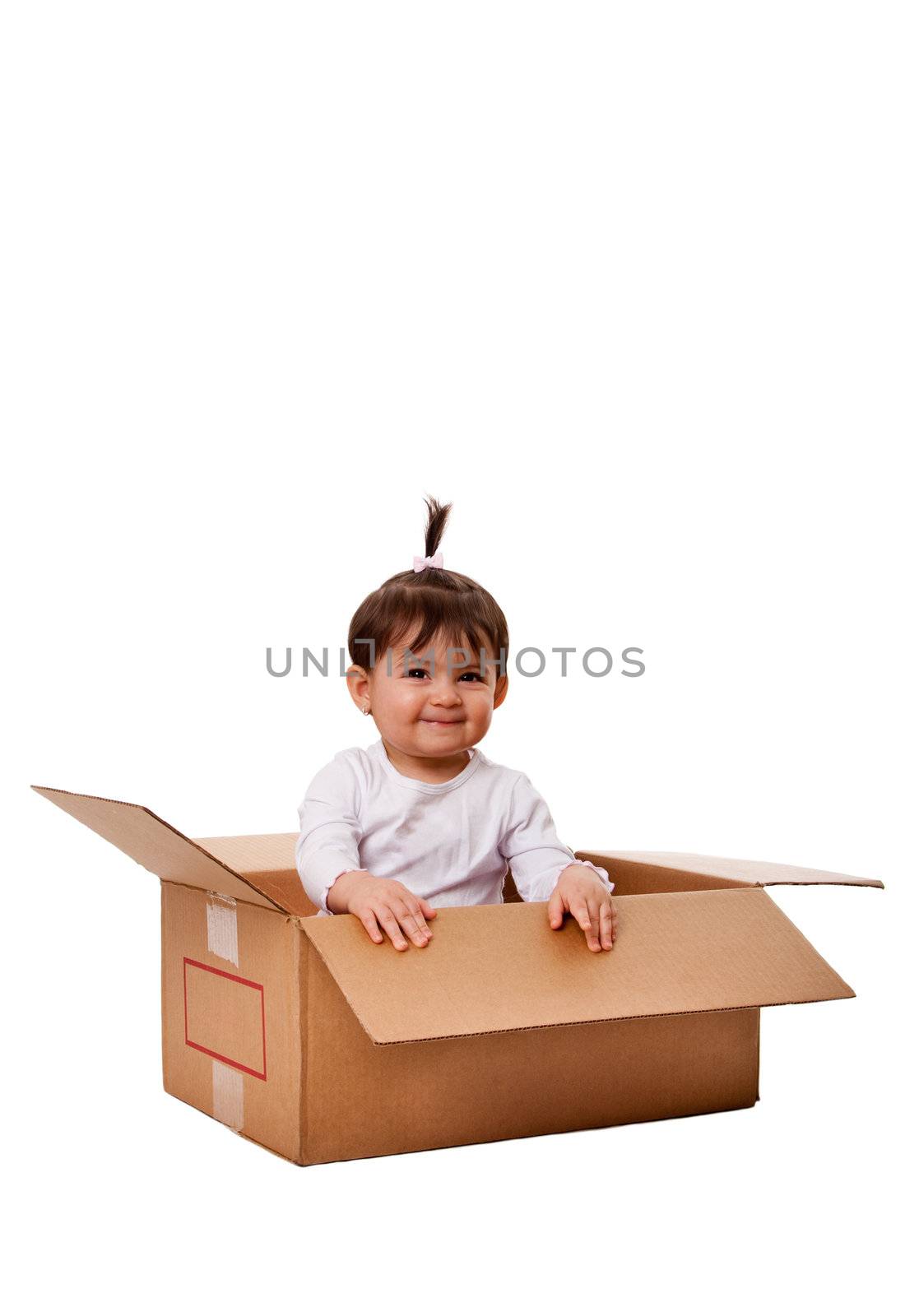 Happy cute baby girl in brown moving storage surprise box, isolated.