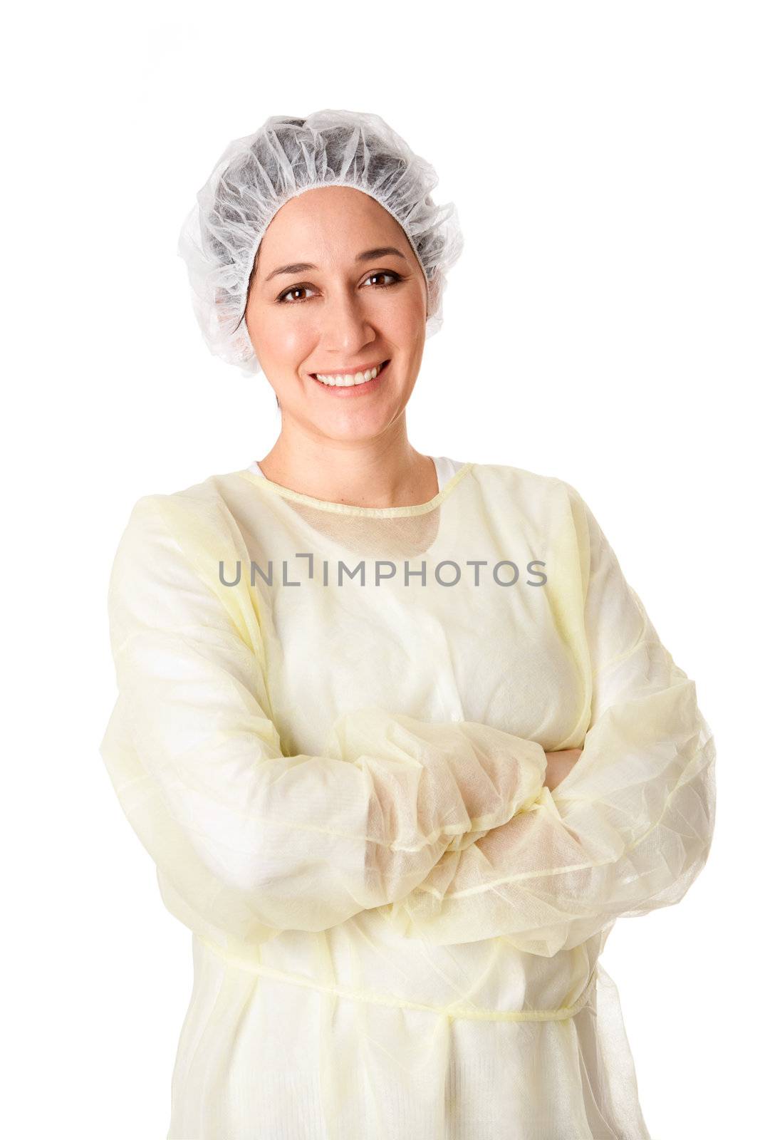 Happy smiling female medical assistant for a surgical team or dentist wearing yellow scrubs and white hair net standing with arms crossed, isolated.