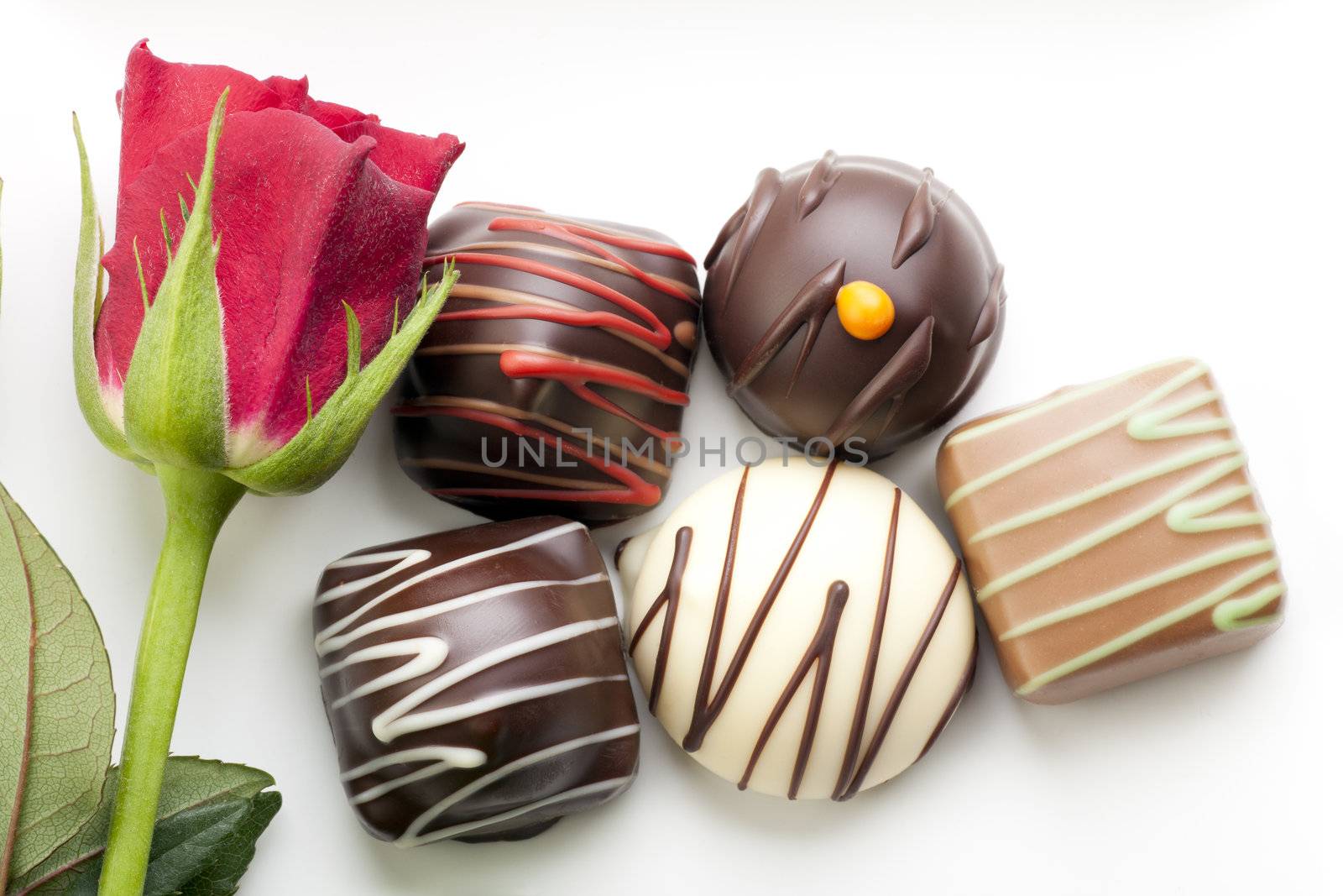 A little romance with a red rose and chocolate bon-bons.
