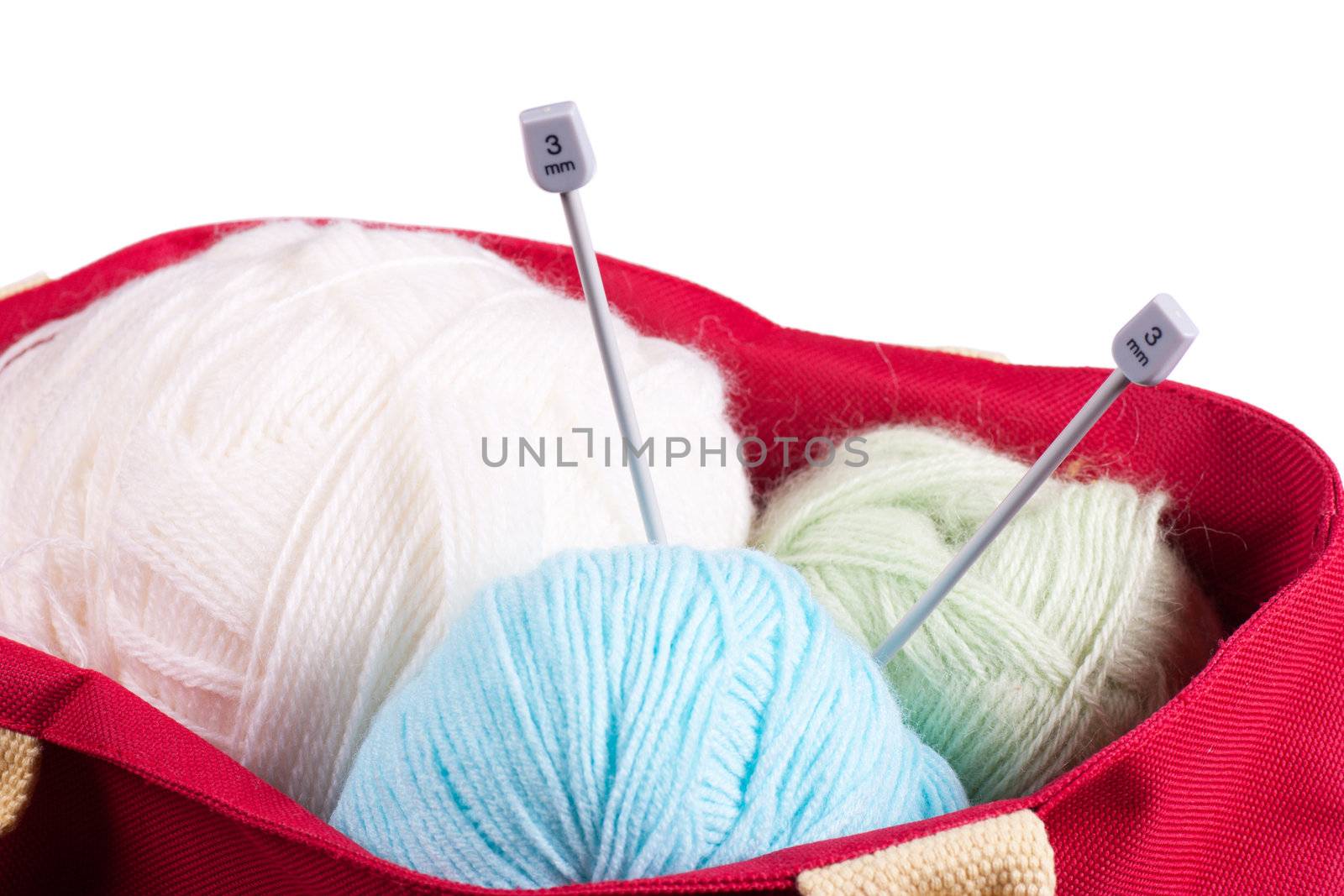 Blue, white and green wool balls in a red bag