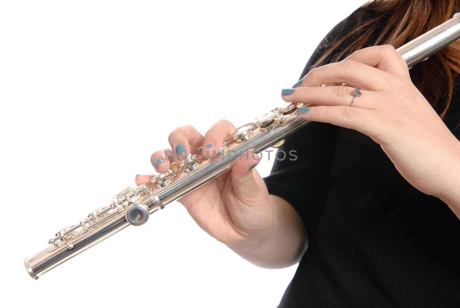A closeup view of a musical flute being played by a girl, isolated against a white background.