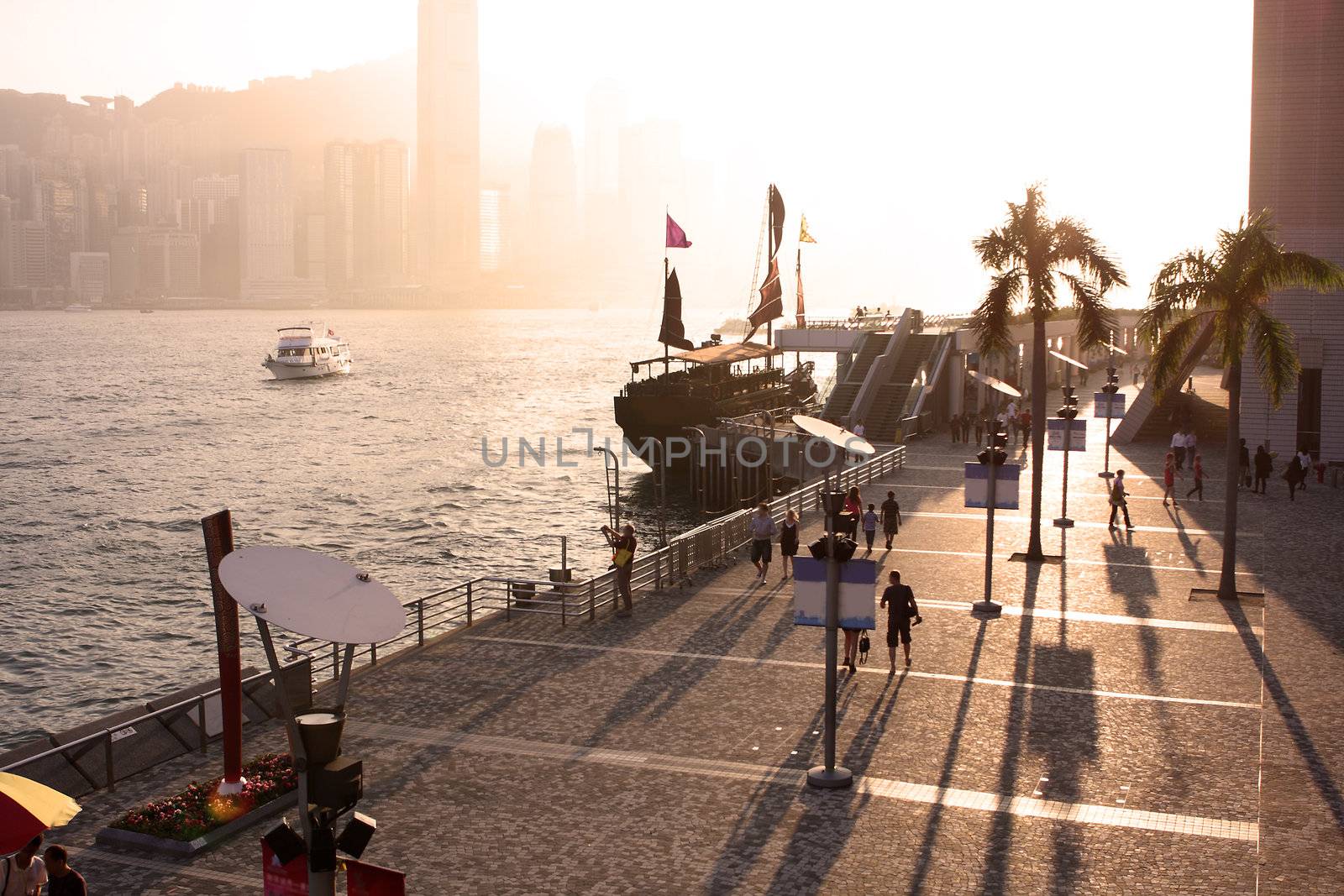hong kong sunset and the people moving ob the plaza