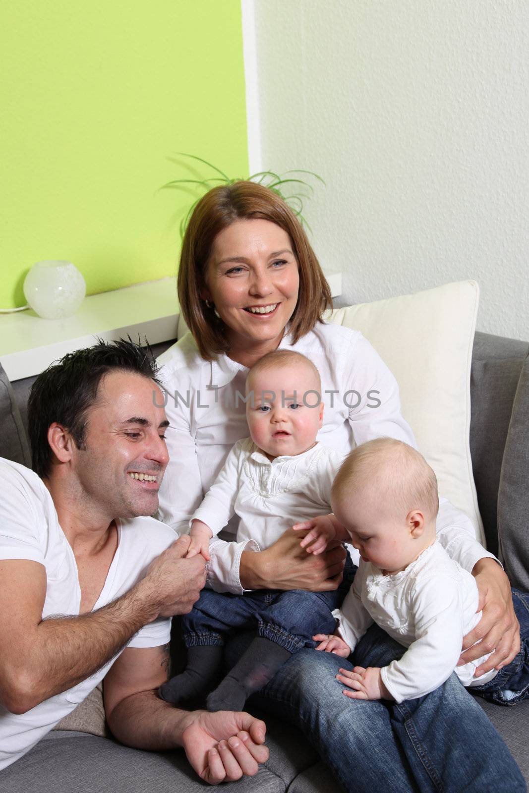 Young parents - mother, father and twins play with your little babies
