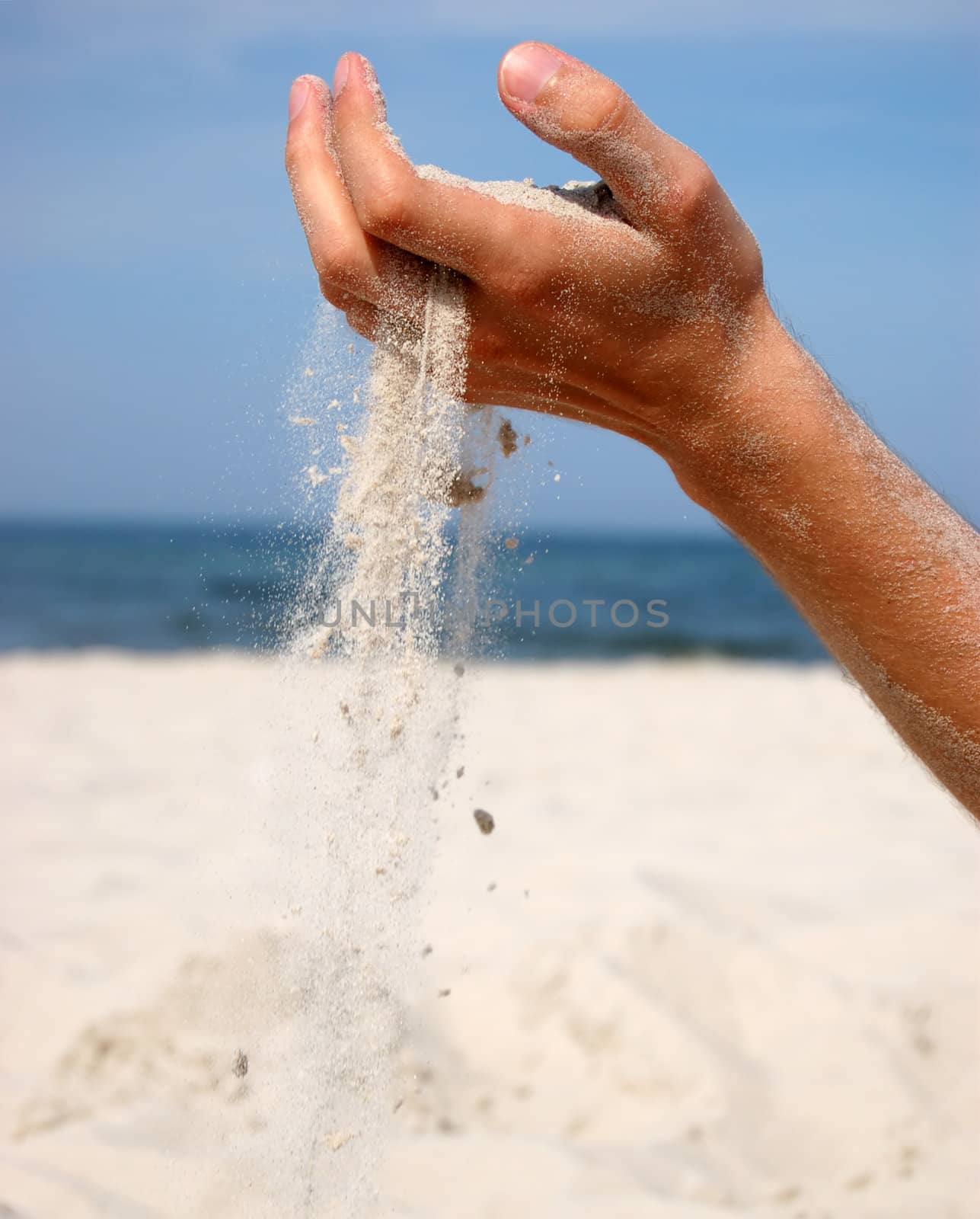 Concept photo of sand falling from the man's hand. 