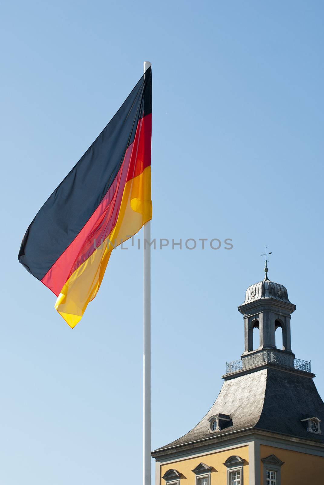 German flag on blue sky and university of Bonn background, photo taken on 1 of October 2011