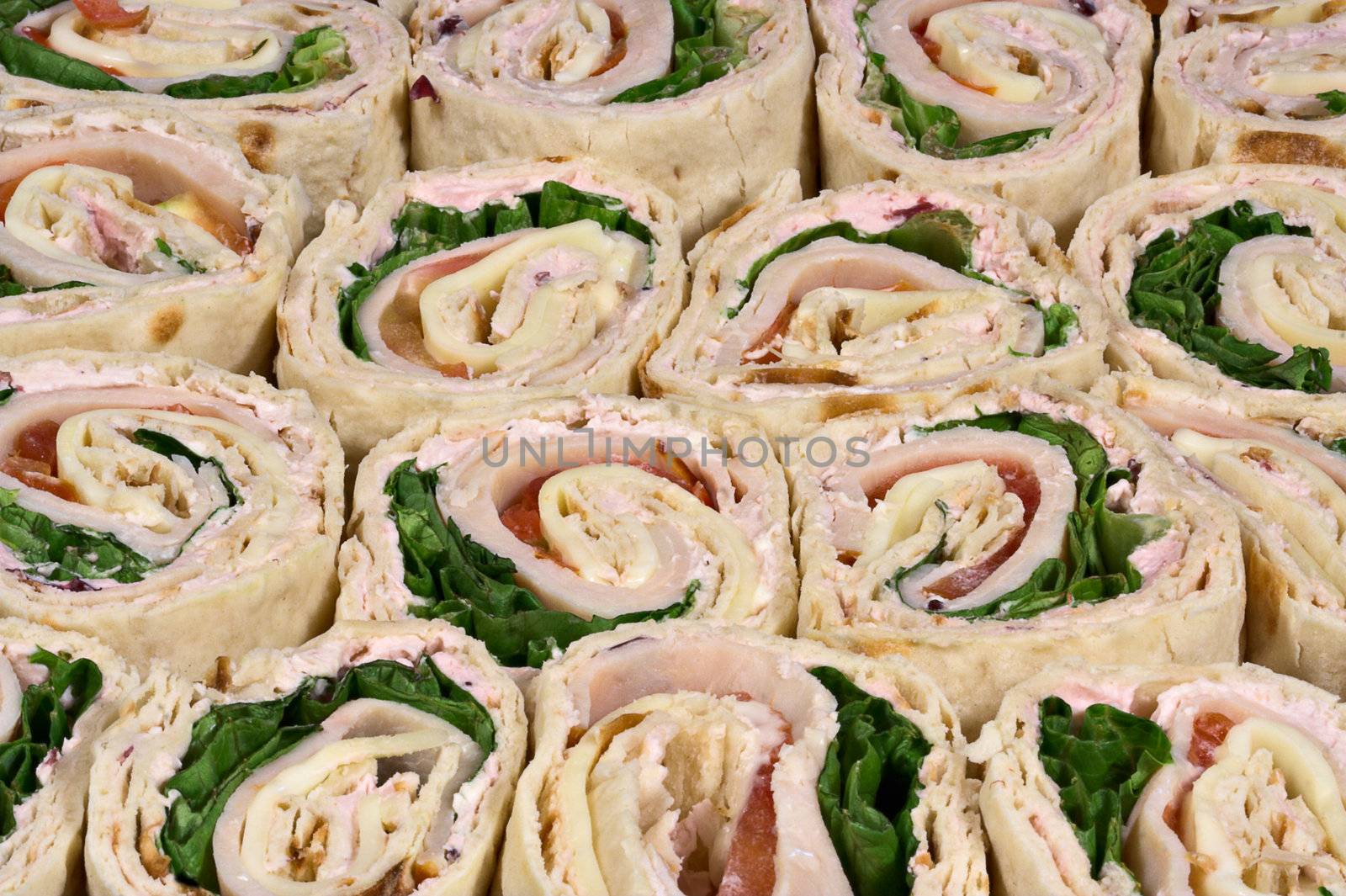 A platter of sliced turkey wrap sandwiches