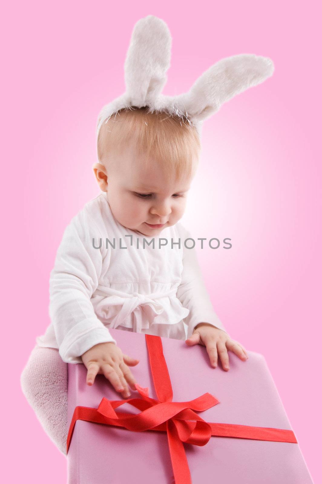 Baby in rabbit costume with pink gift