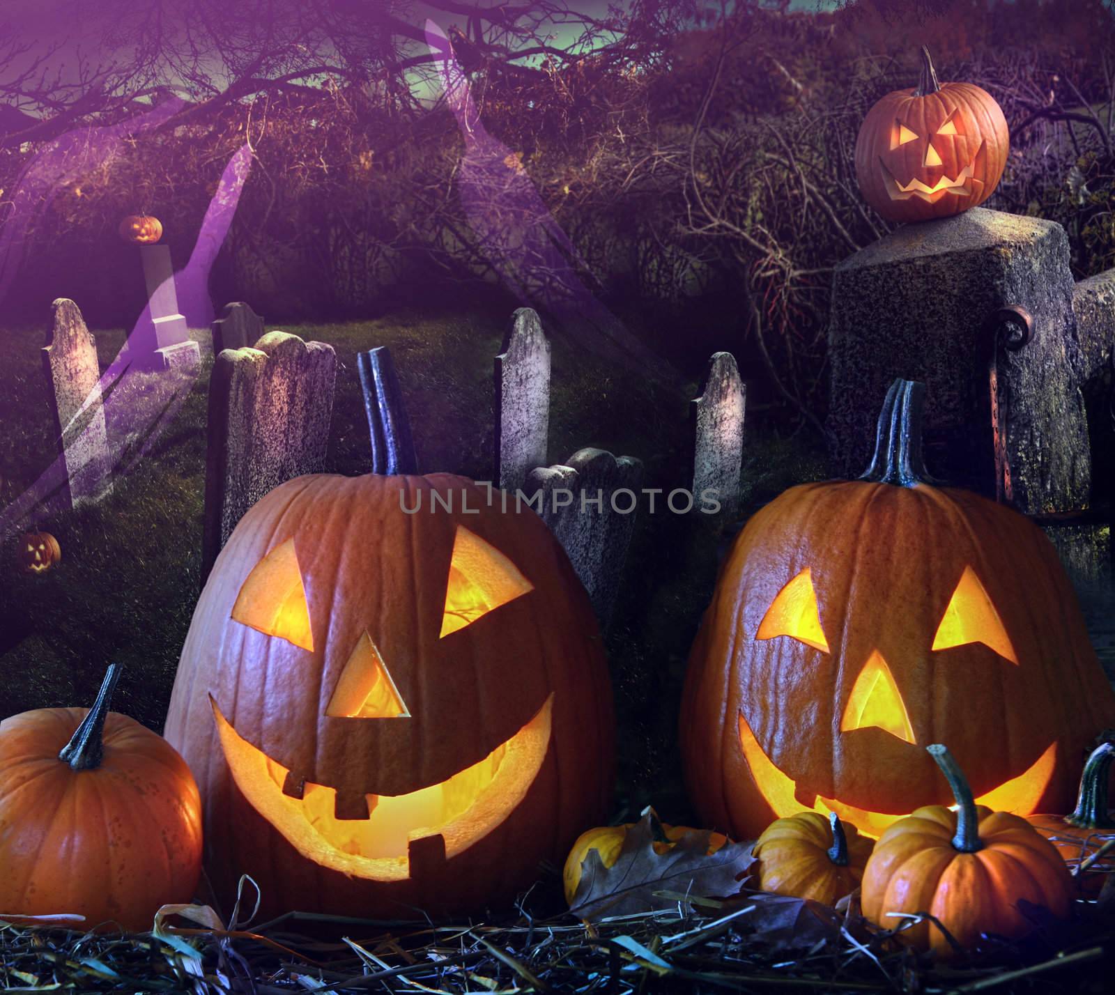 Brightly lit Halloween pumpkins in the grave yard