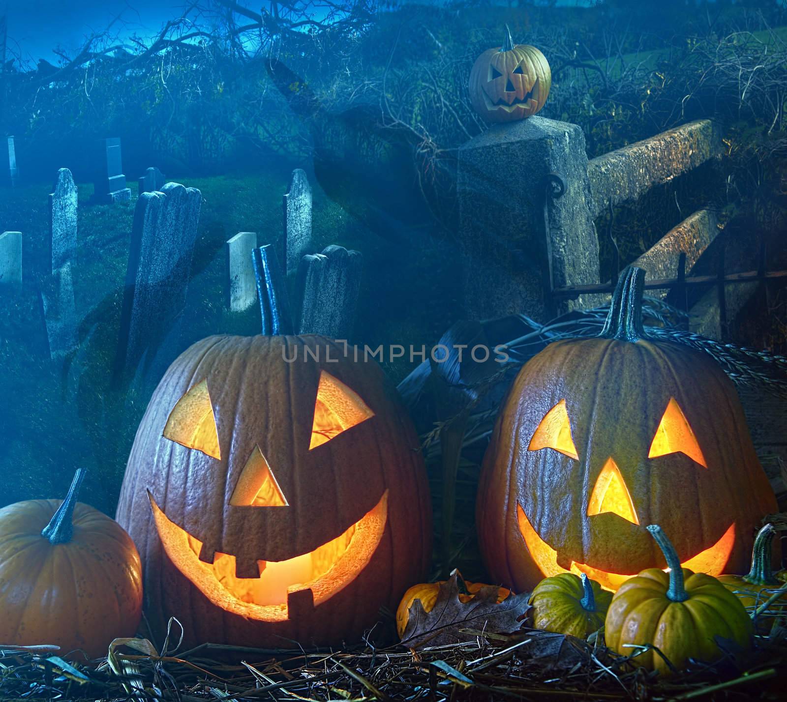 Brightly lit Halloween pumpkins in the grave yard
