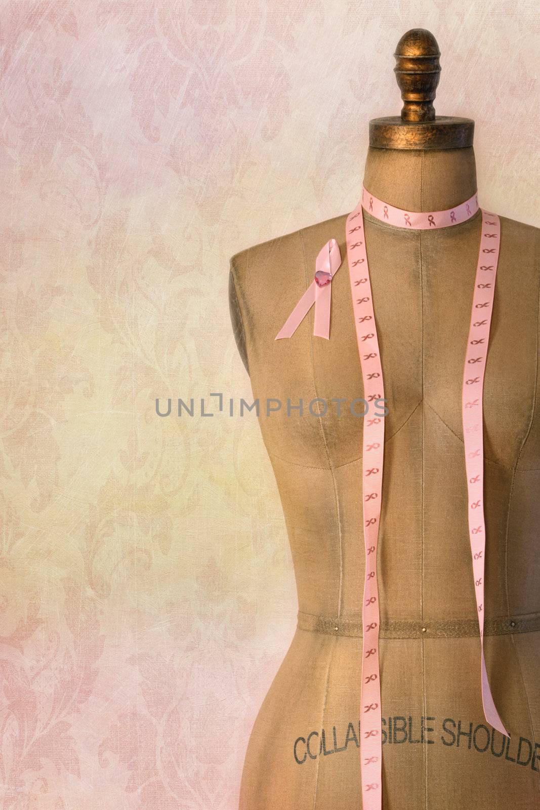 Pink breast cancer ribbon on mannequin with vintage background by Sandralise