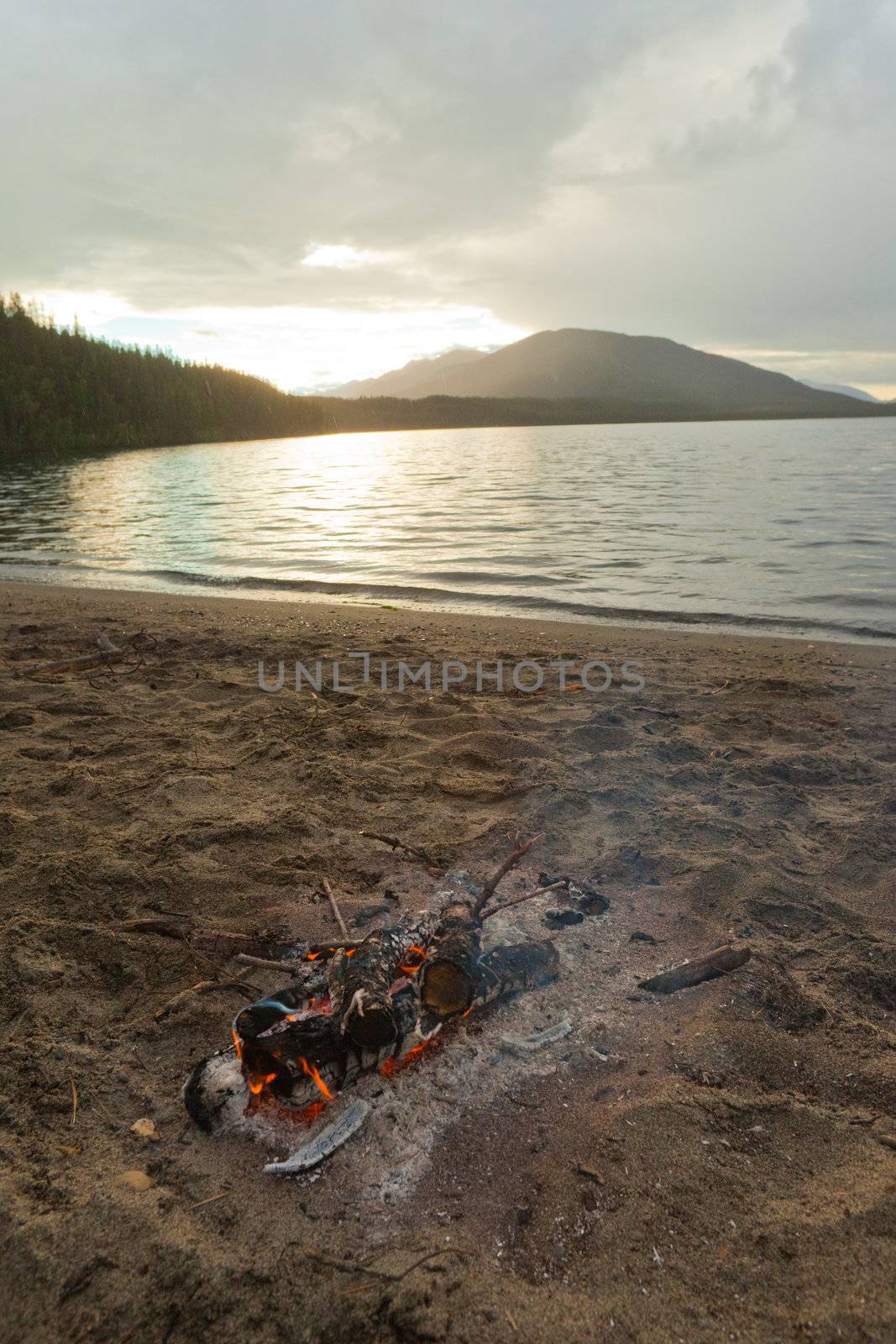 Small campfire on remote lake shore in northern Canada.