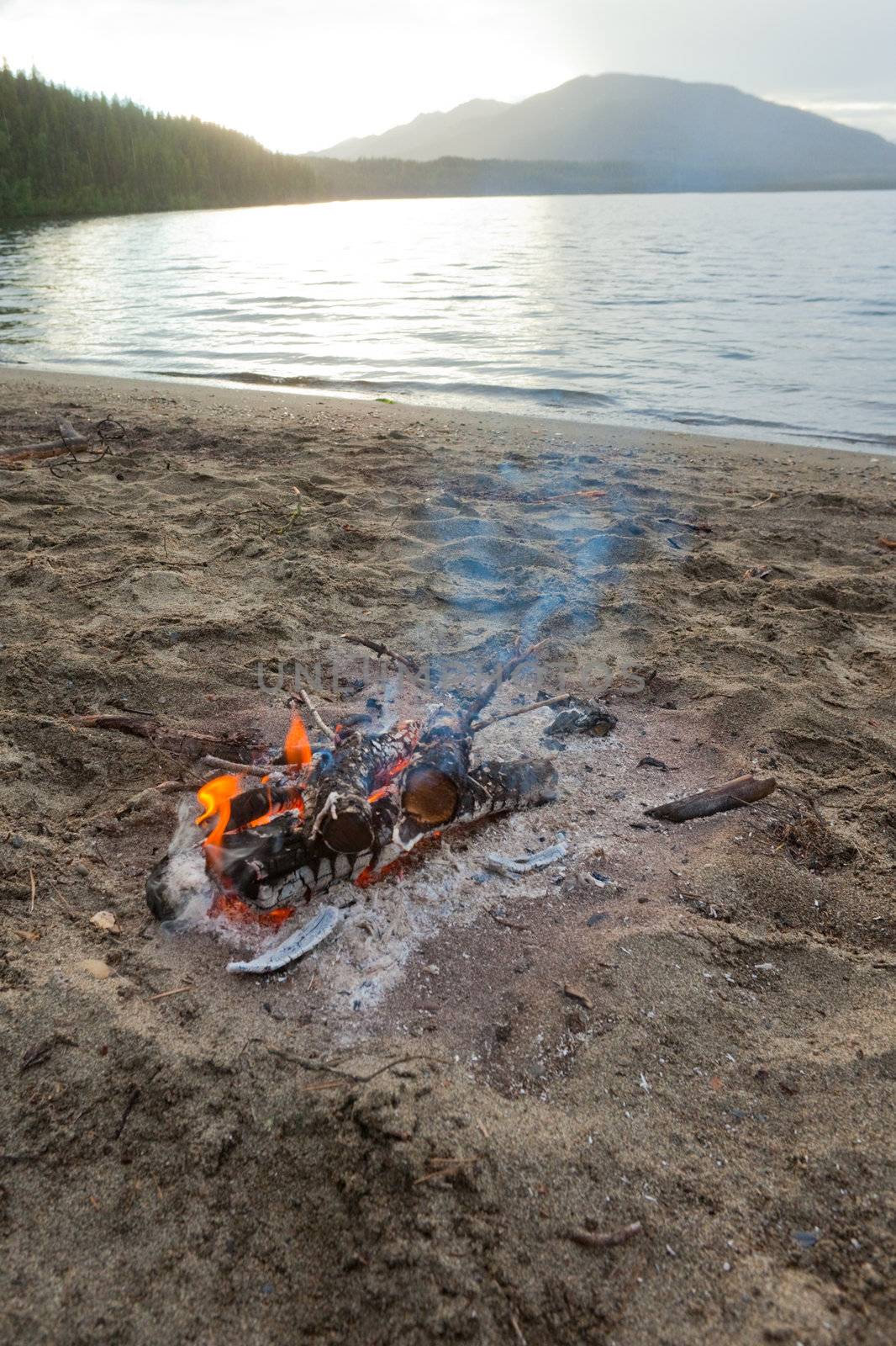 Small campfire on remote lake shore in northern Canada.