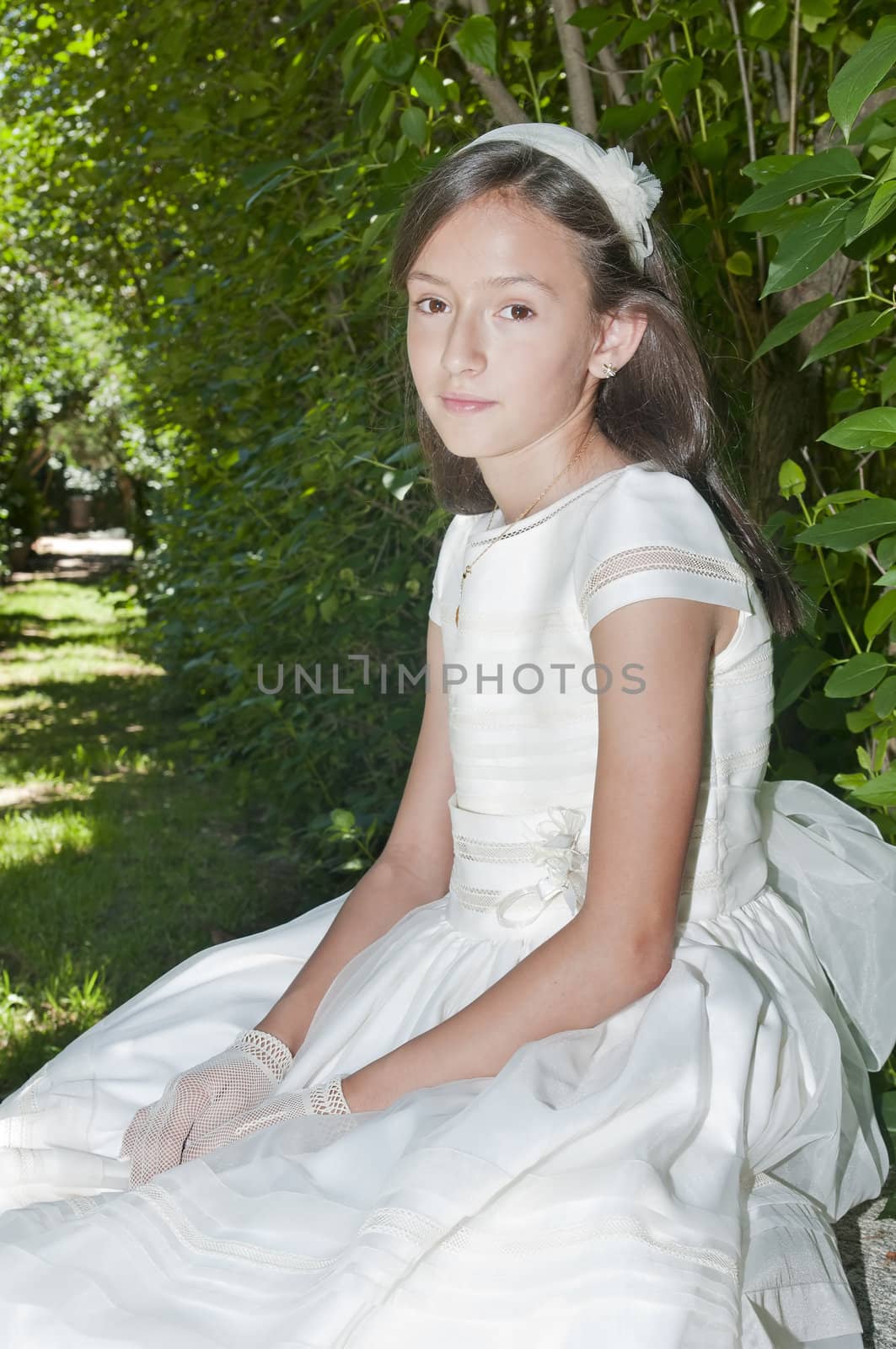 girl white dress the day of their first communion
