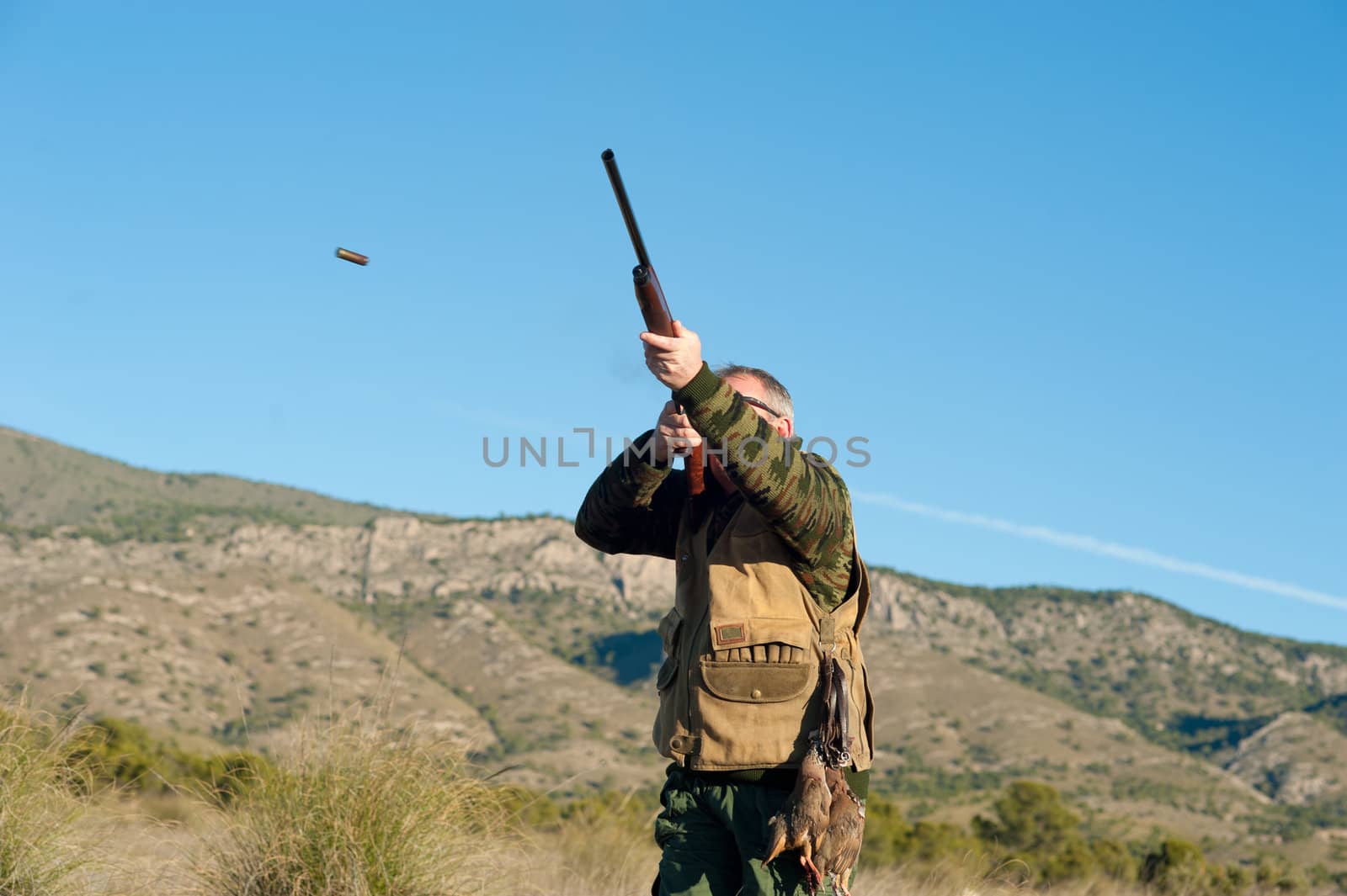 Hunter in action aiming and shooting his rifle