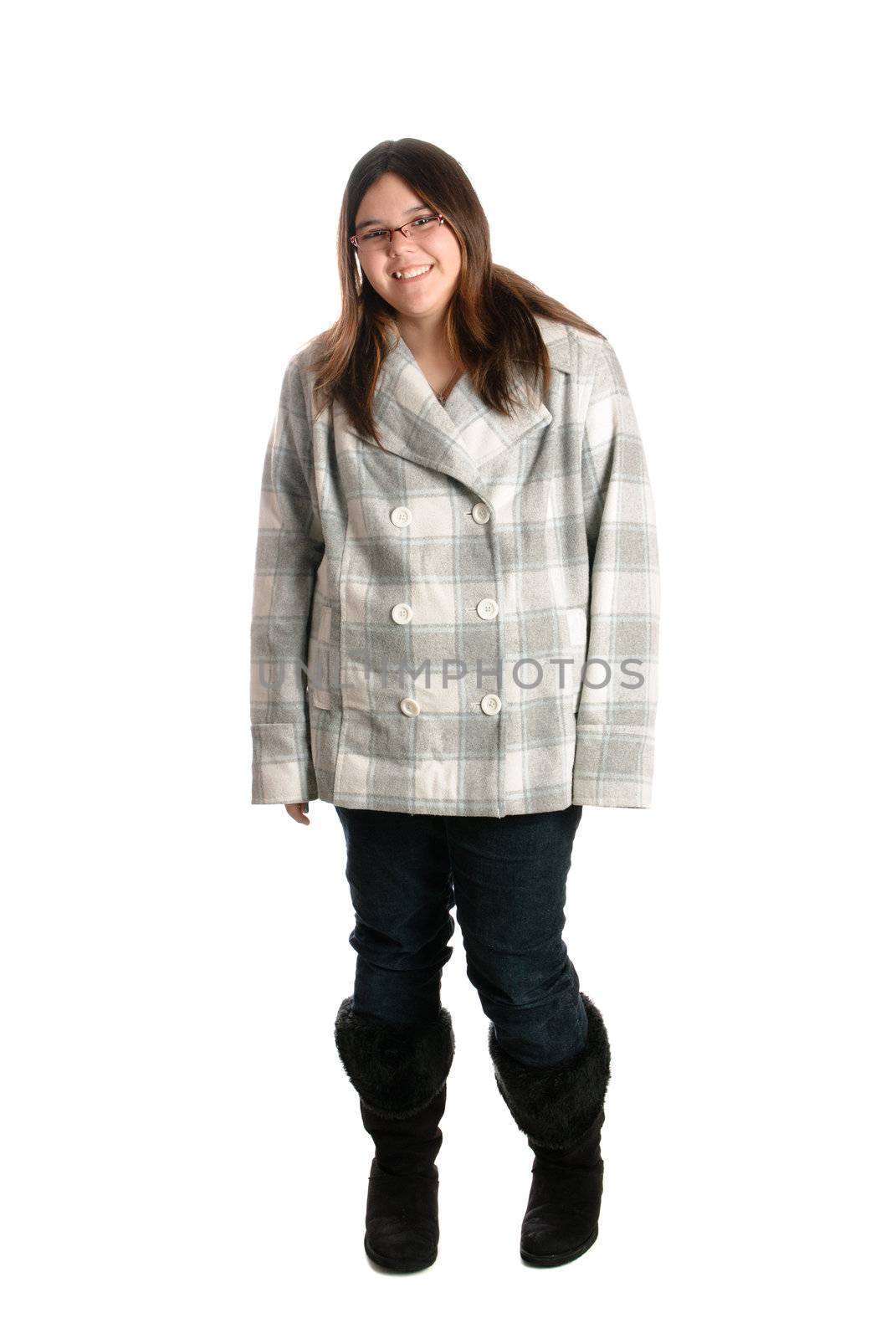 A full body view of a smiling brunette teenage girl is posing while wearing winter clothing, isolated against a white background