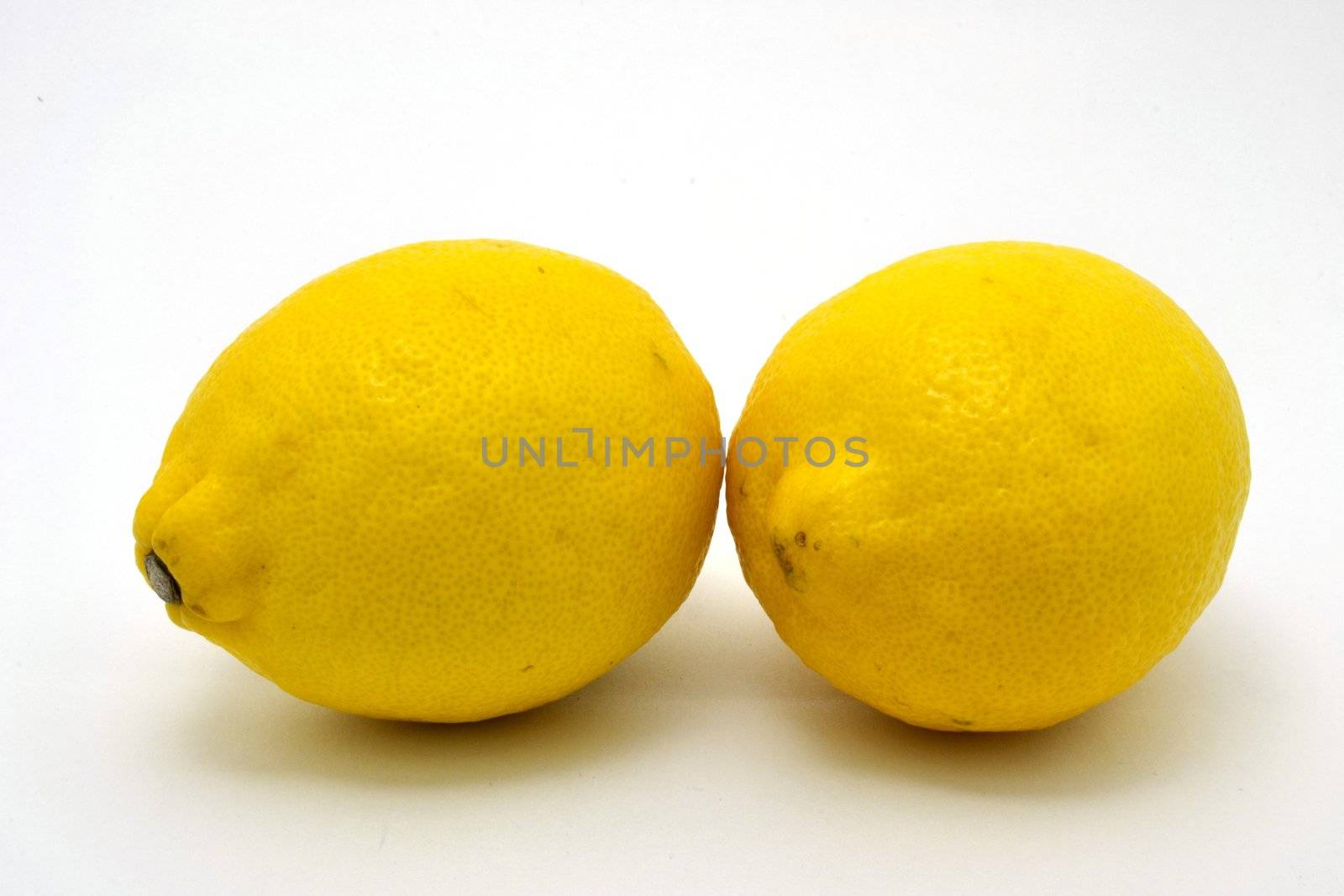 Two fresh  lemons over the white background
