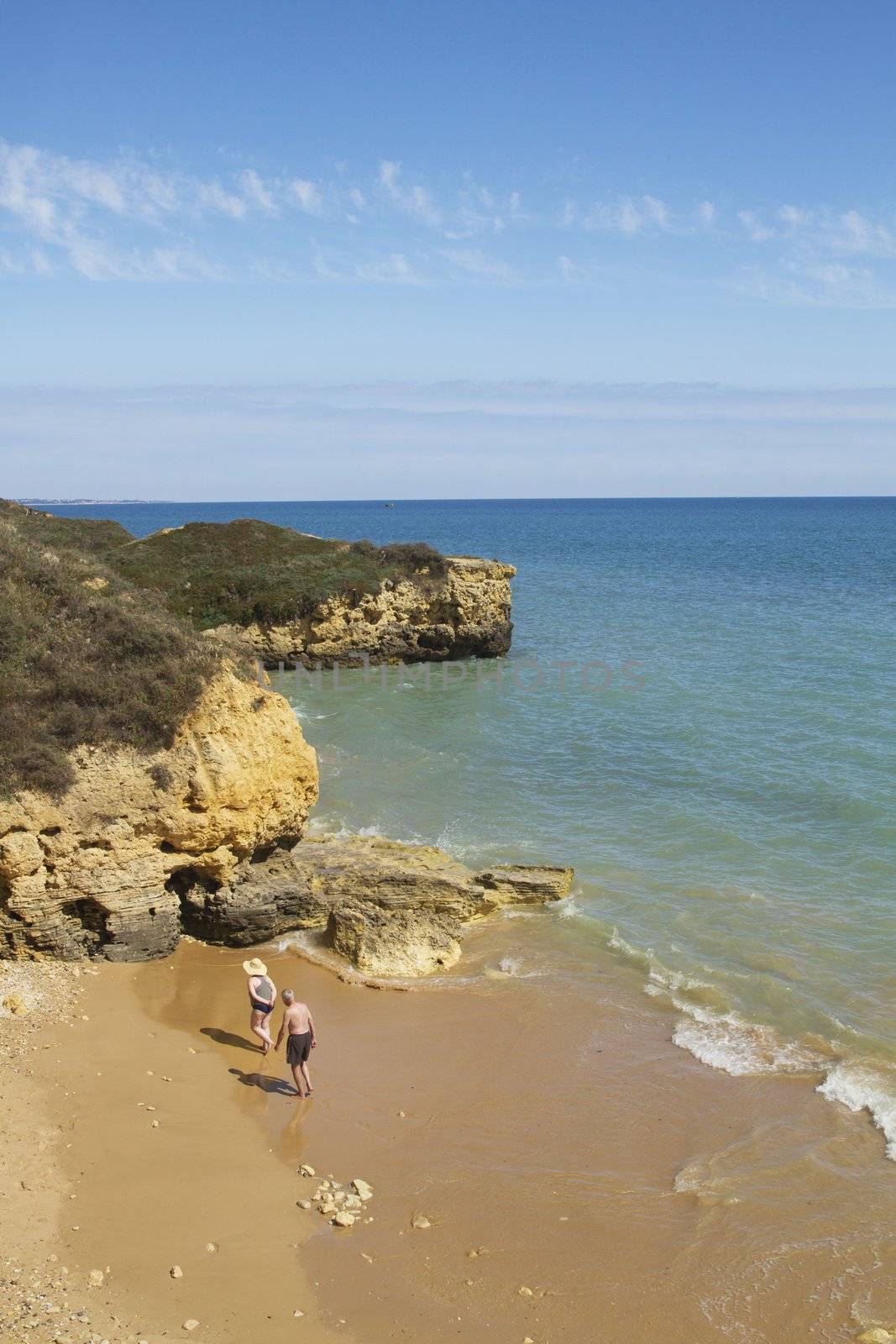 View of two older couple walking on the beach.