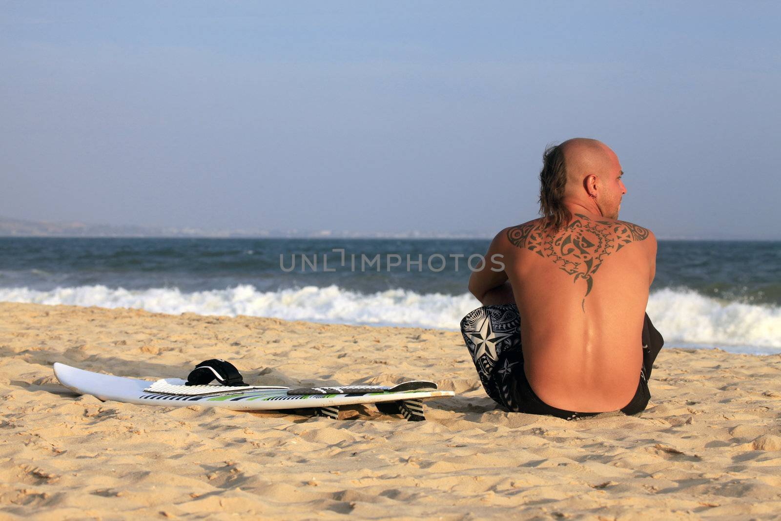 Kitesurfer with surferboard pending a wind