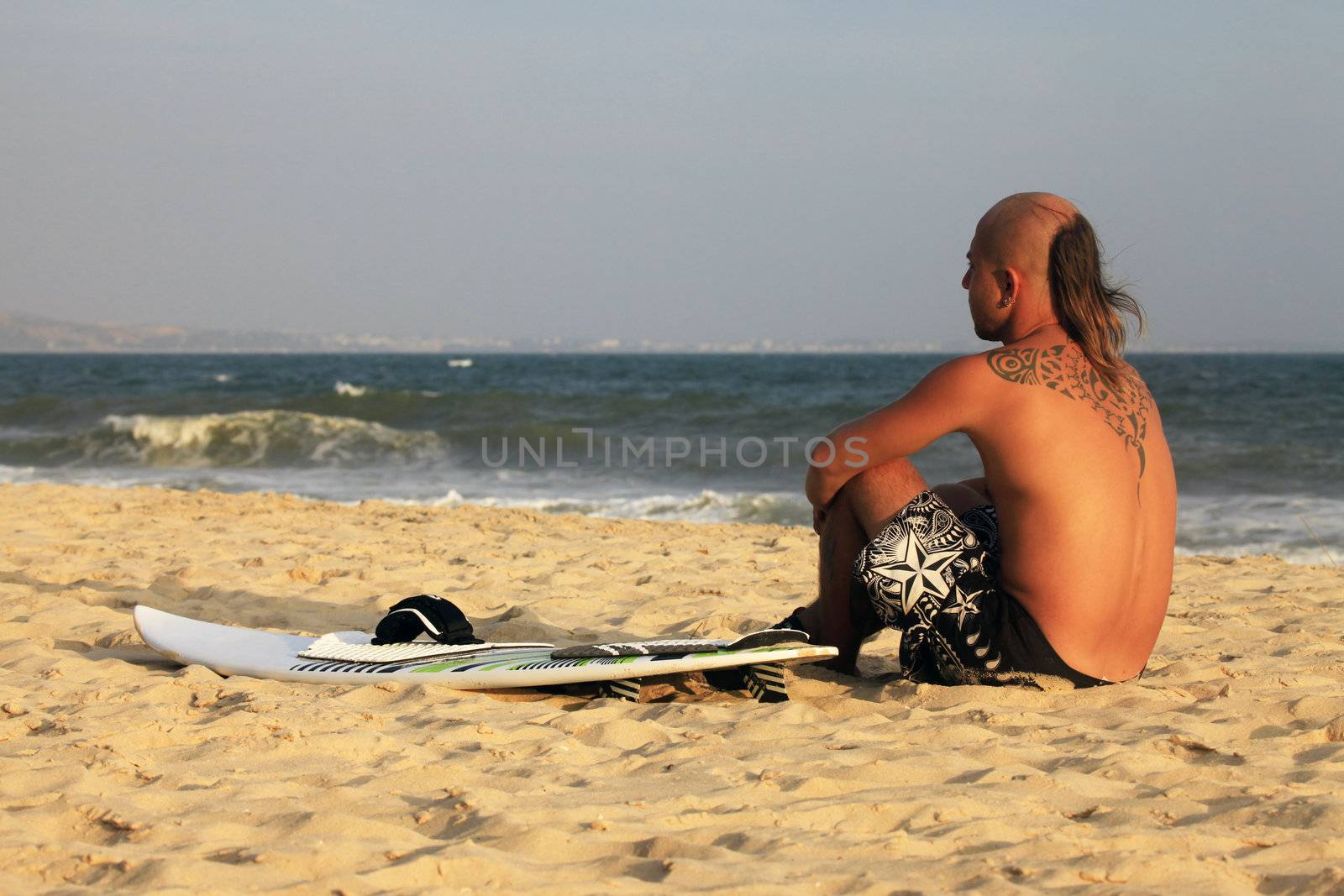 Kitesurfer with surferboard pending a wind