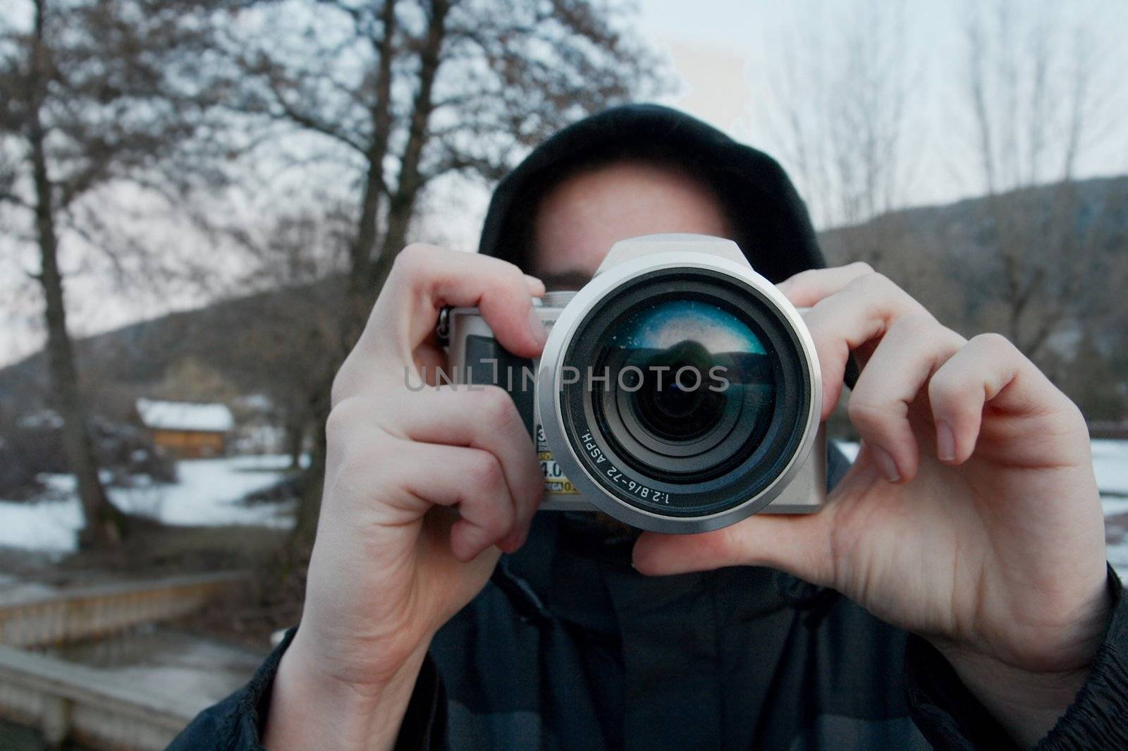 Person photographing outdoors with a compact camera
