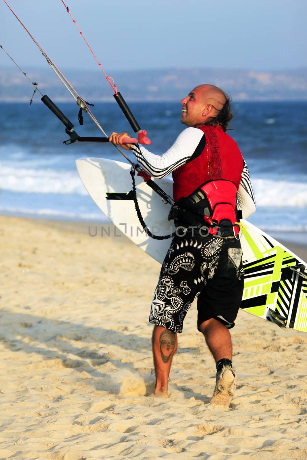 Kitesurfer with surferboard on the beach