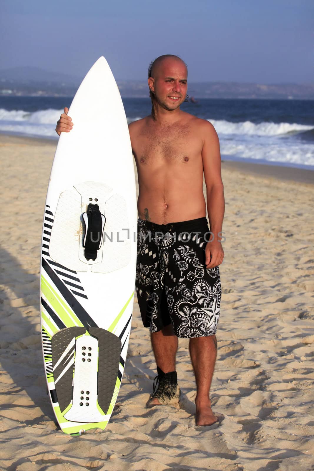 Kitesurfer with surferboard pending a wind