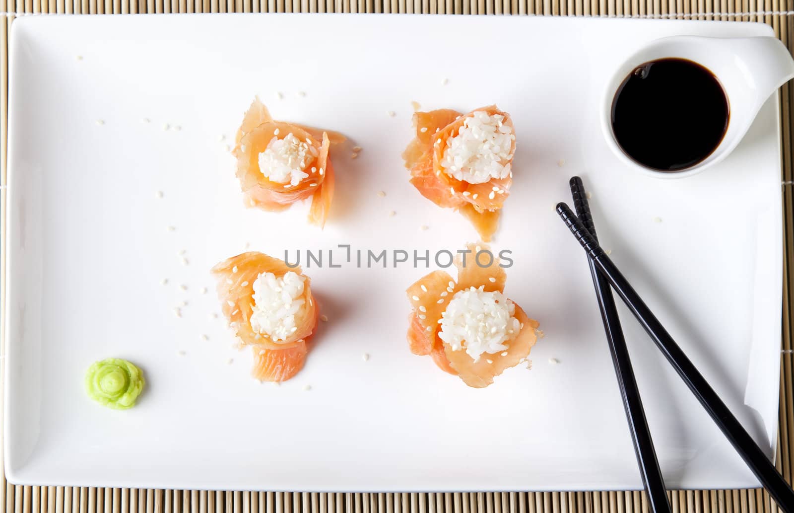 Fresh salmon sushi, filled with rice and sprinkled with sesame seeds.