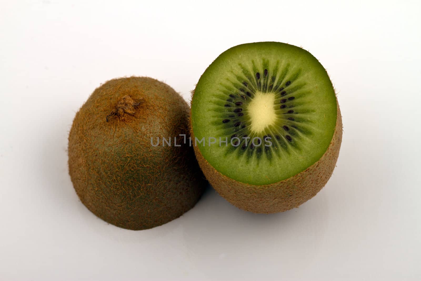 Kiwi halved and placed on white surface