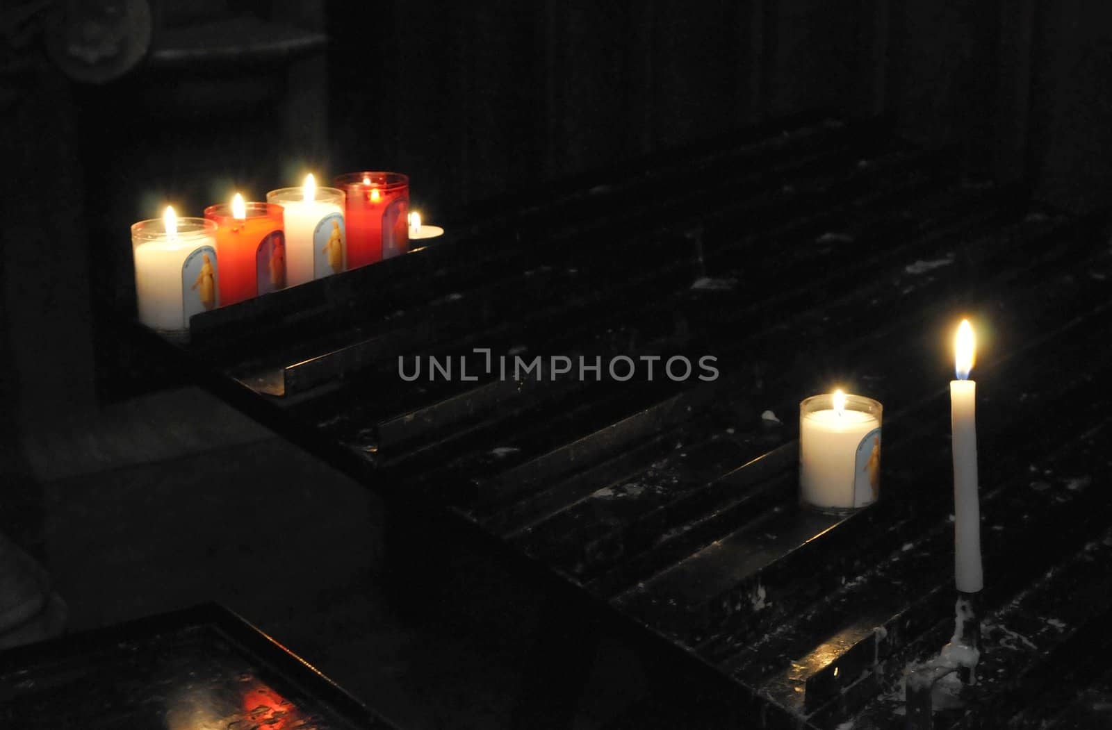 Some religious candles on a black support in a church