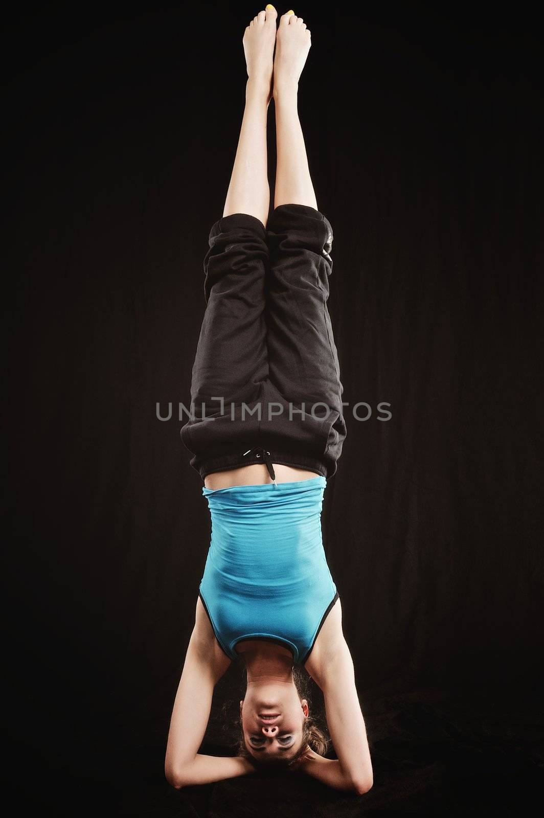 Young woman in tracksuit do yoga poses on head