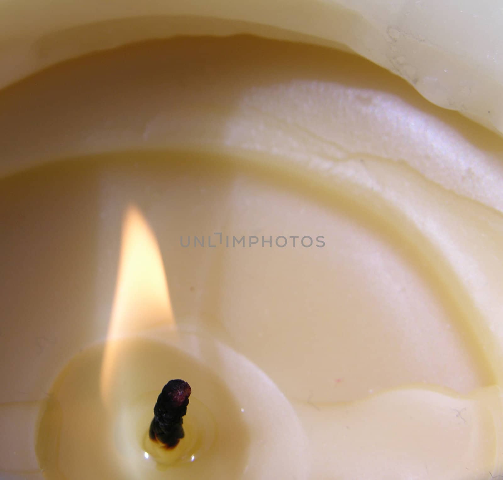 A candle burning bright, shown closeup