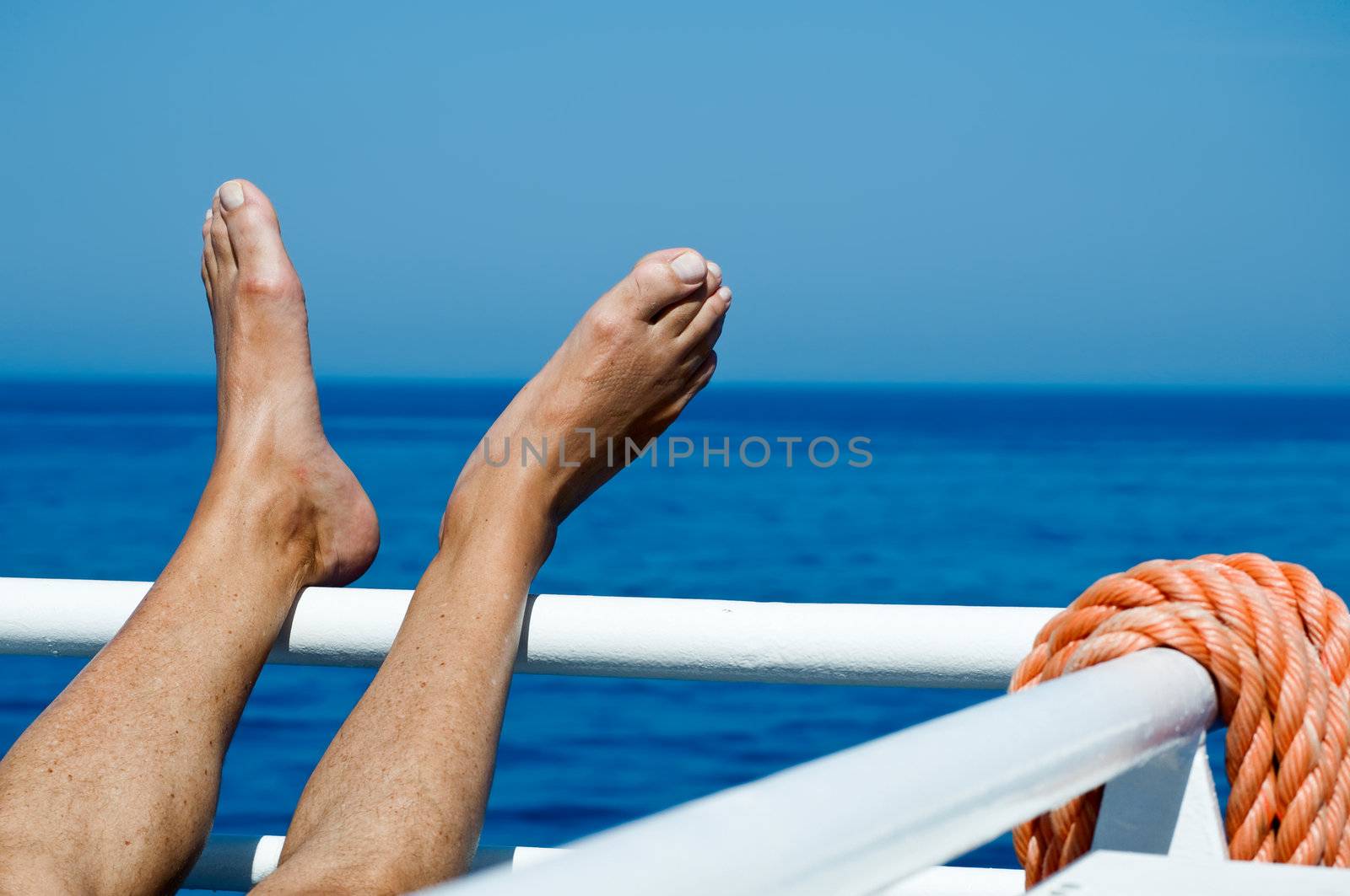 Feet on the railing on a cruise liner