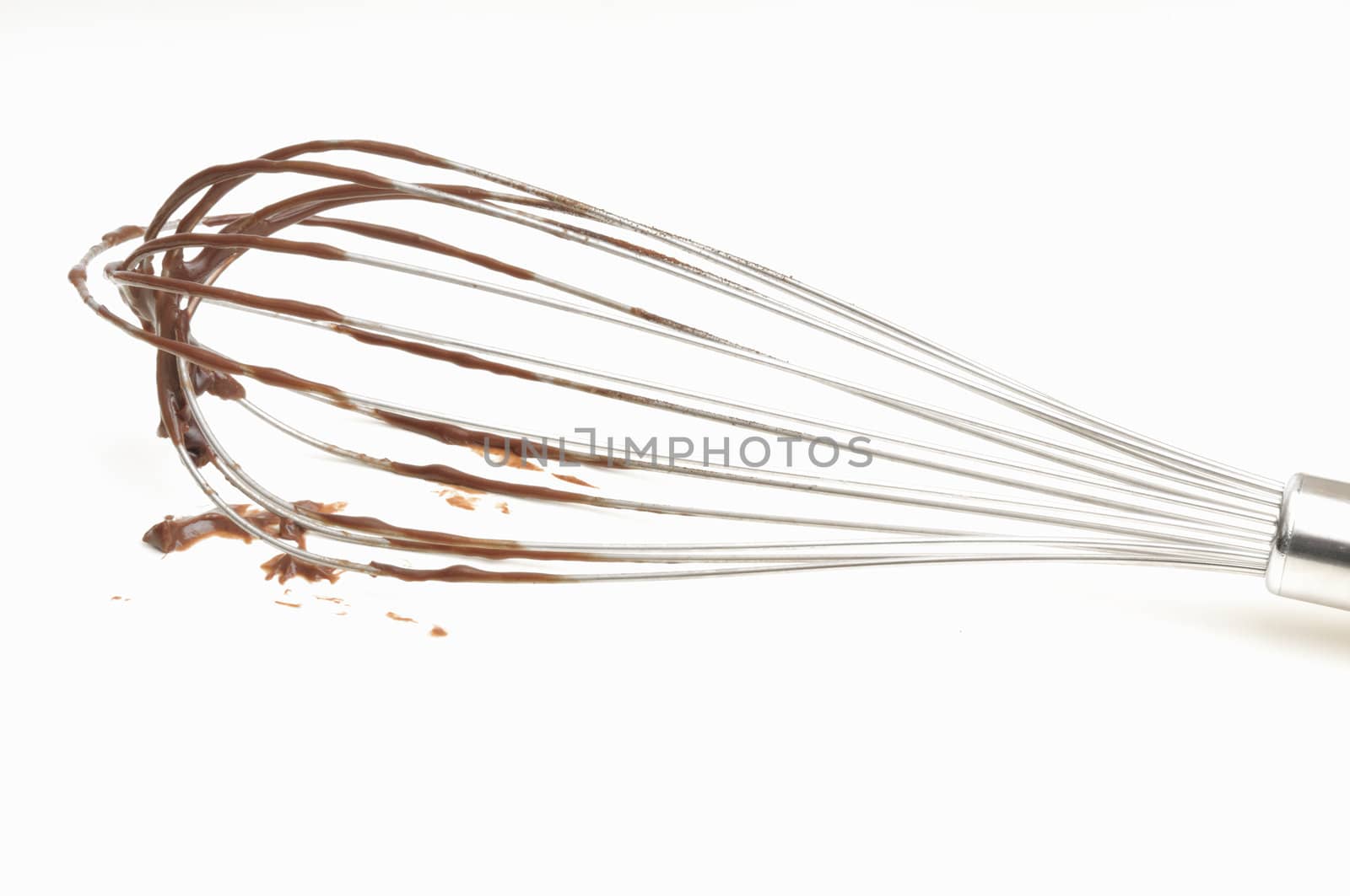 Whisk with chocolate cream on a white background