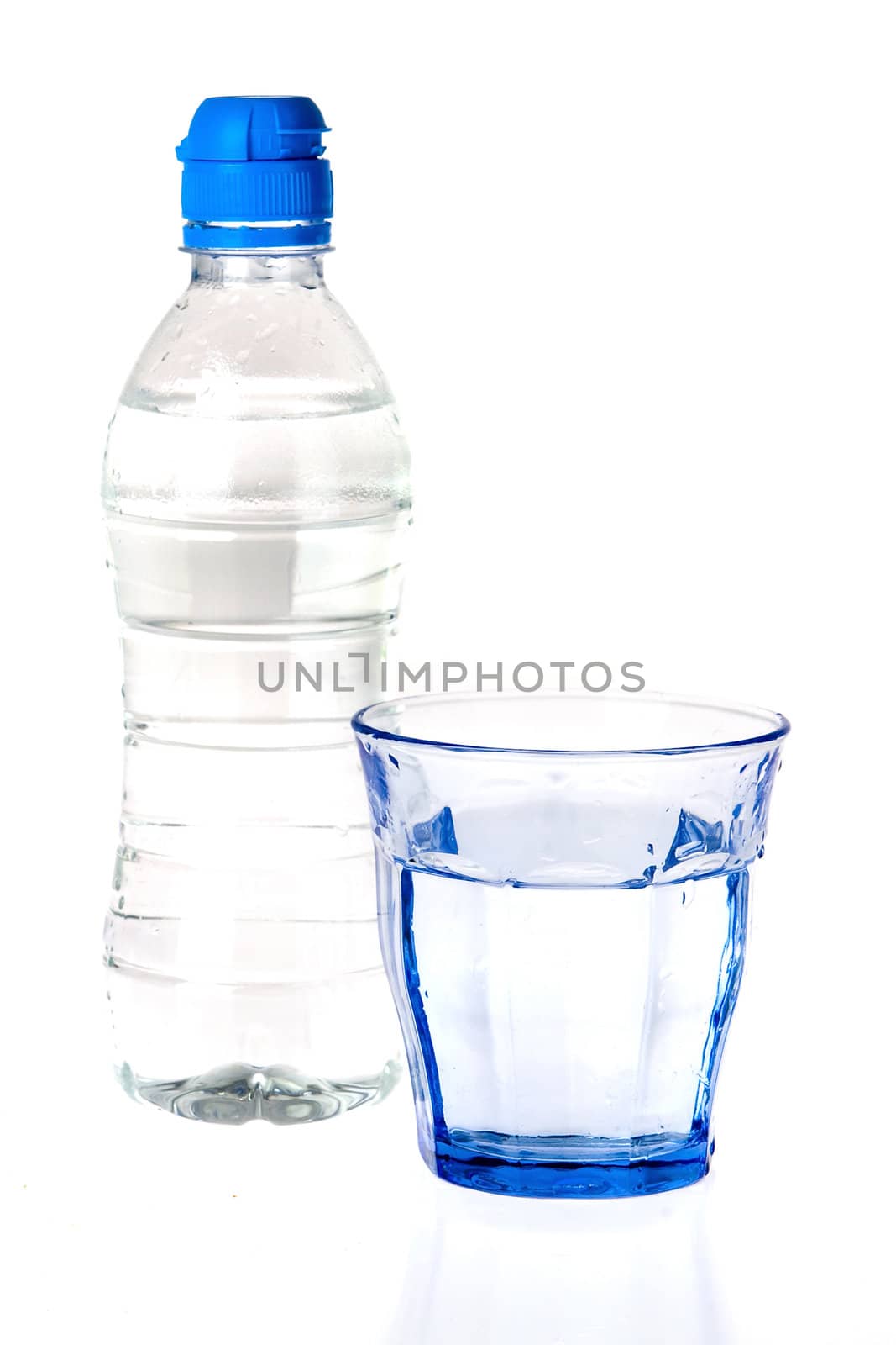 a blue glass and a bottle of water on a white background