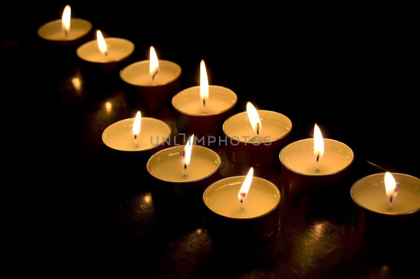 Group of church candles burning in the darkness