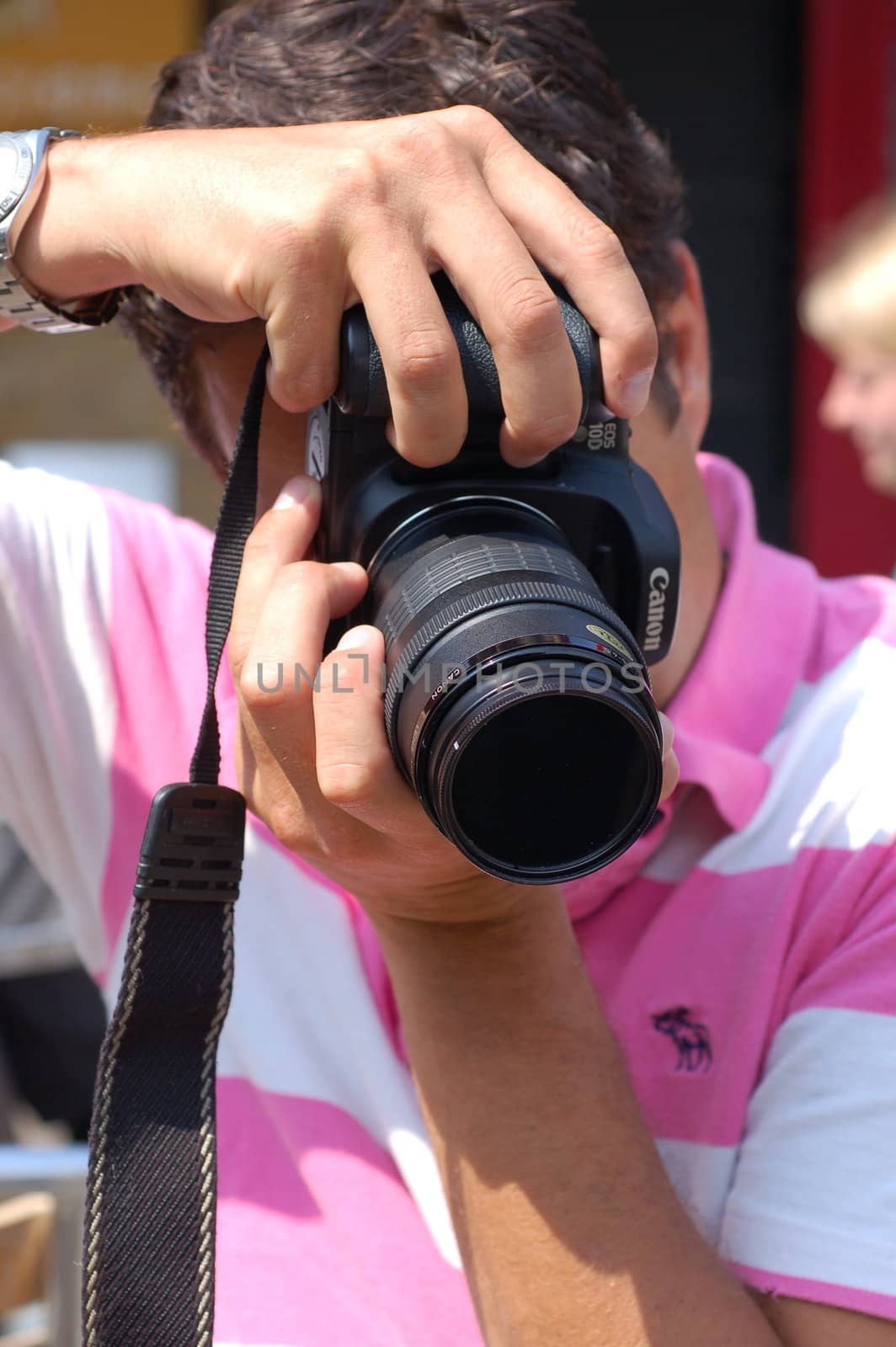 Male photographer holding camera up to eye to take a shot.