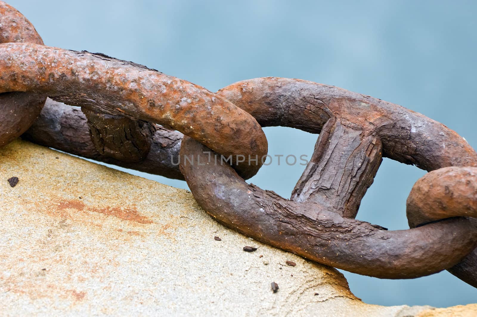 Closeup of an old rusty chain on a pier