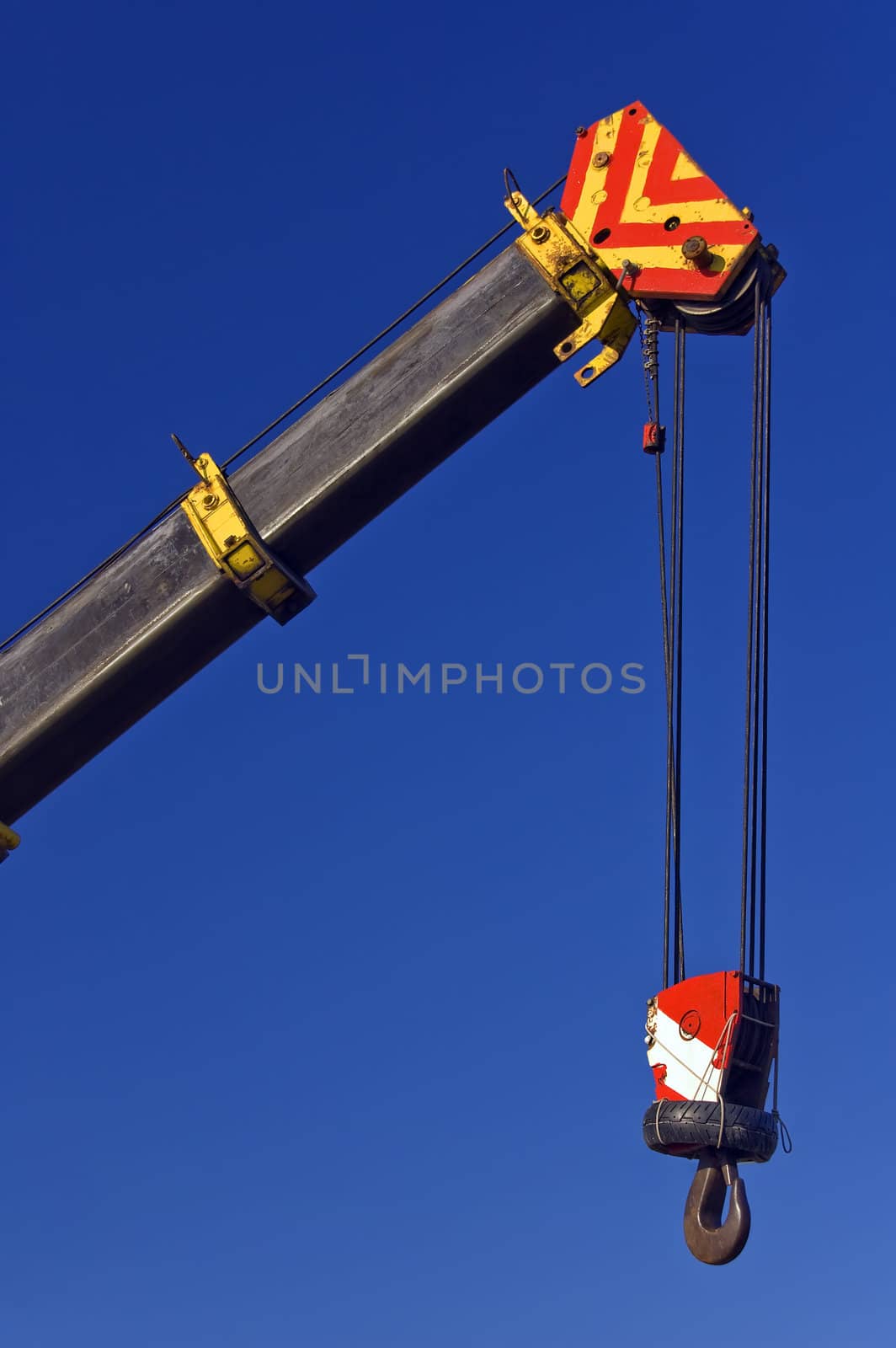 Crane with hook against blue sky