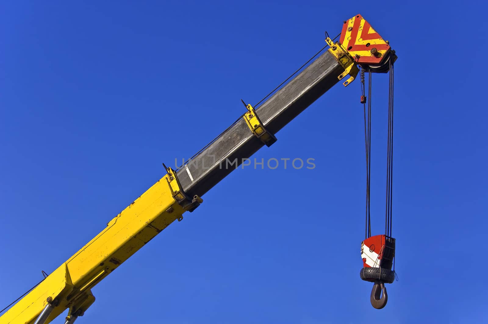 Crane with hook against blue sky